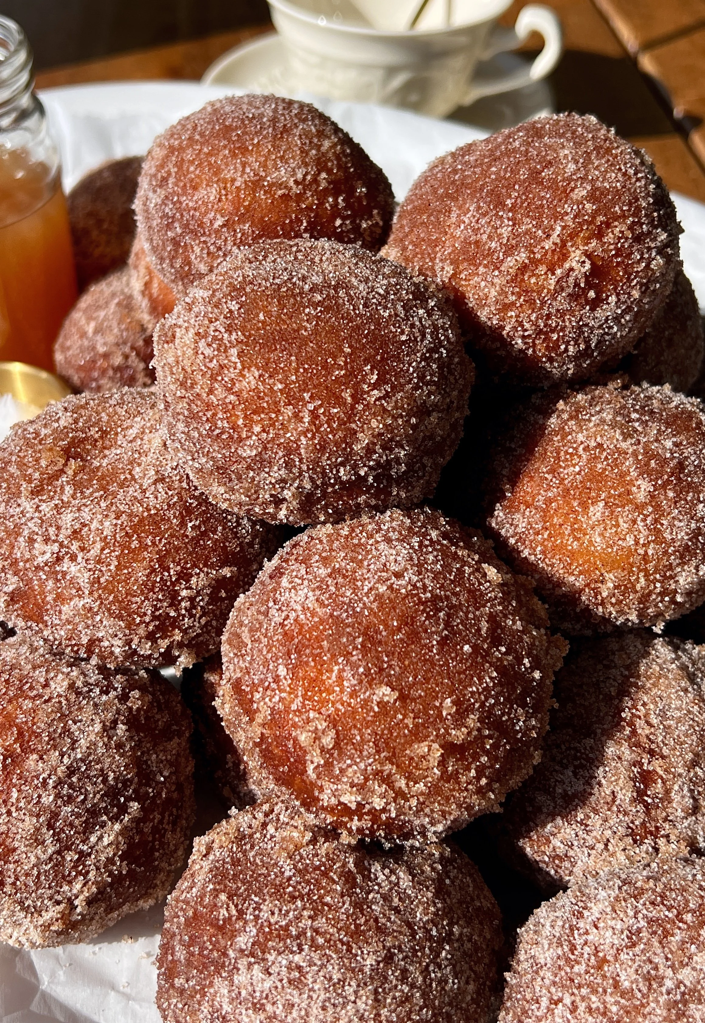 Close-up of an apple cider cinnabon delight showing the soft pillowy golden exterior rolled in cinnamon sugar with a sweet tangy cream cheese filling inside.