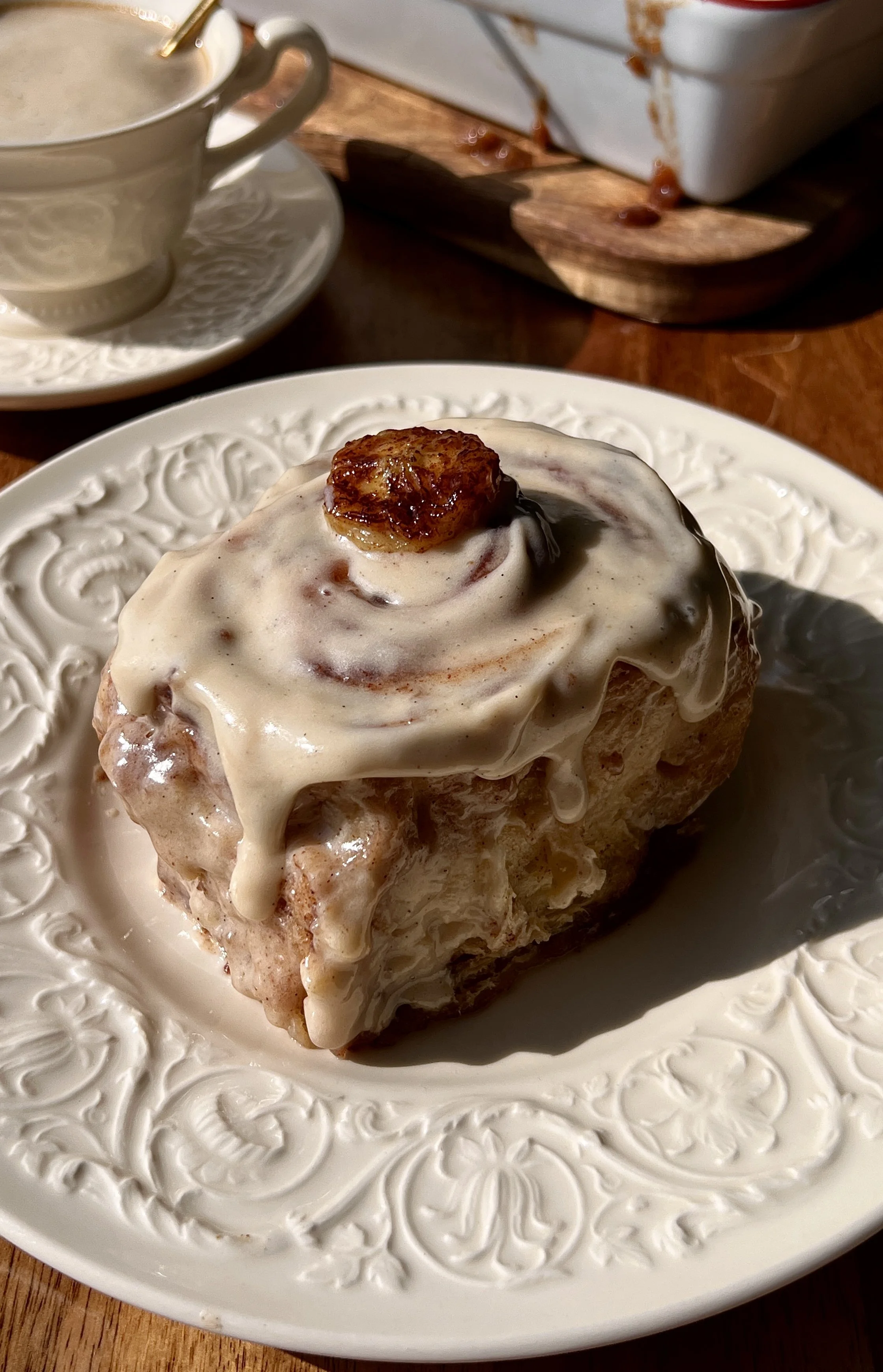 Banana bread buttermilk cinnamon rolls with honey brown sugar cream cheese frosting served warm with a hot cup of coffee.