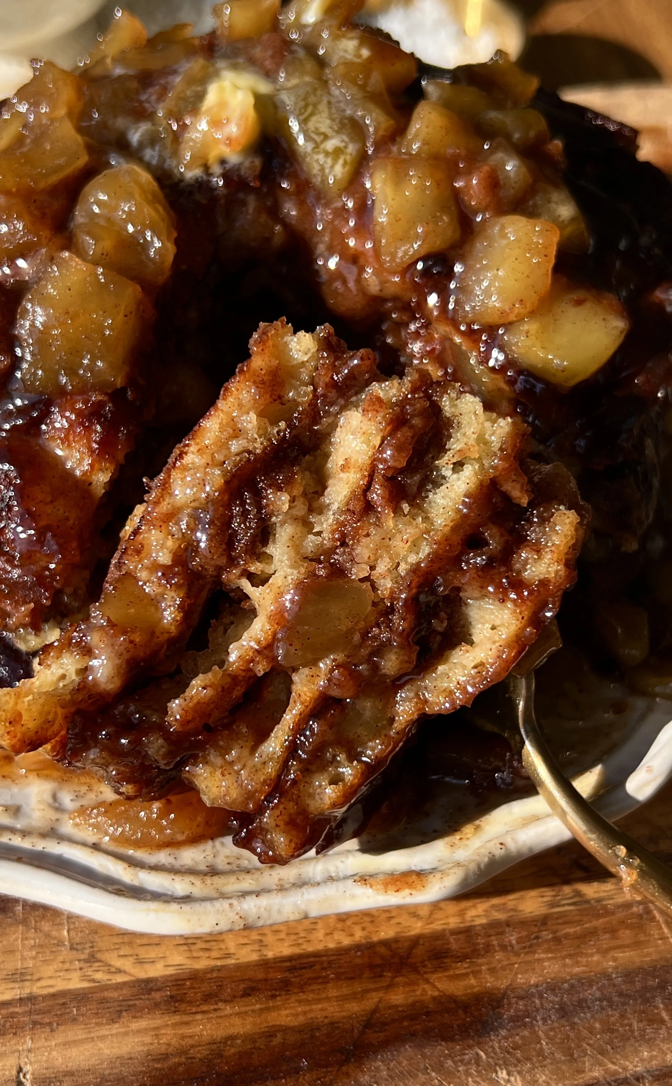 Close-up of a soft and fluffy apple streusel griddle cake showing the golden exterior with crisp edges, warm gooey apple filling laced throughout, and caramelized cinnamon streusel melted into the middle.