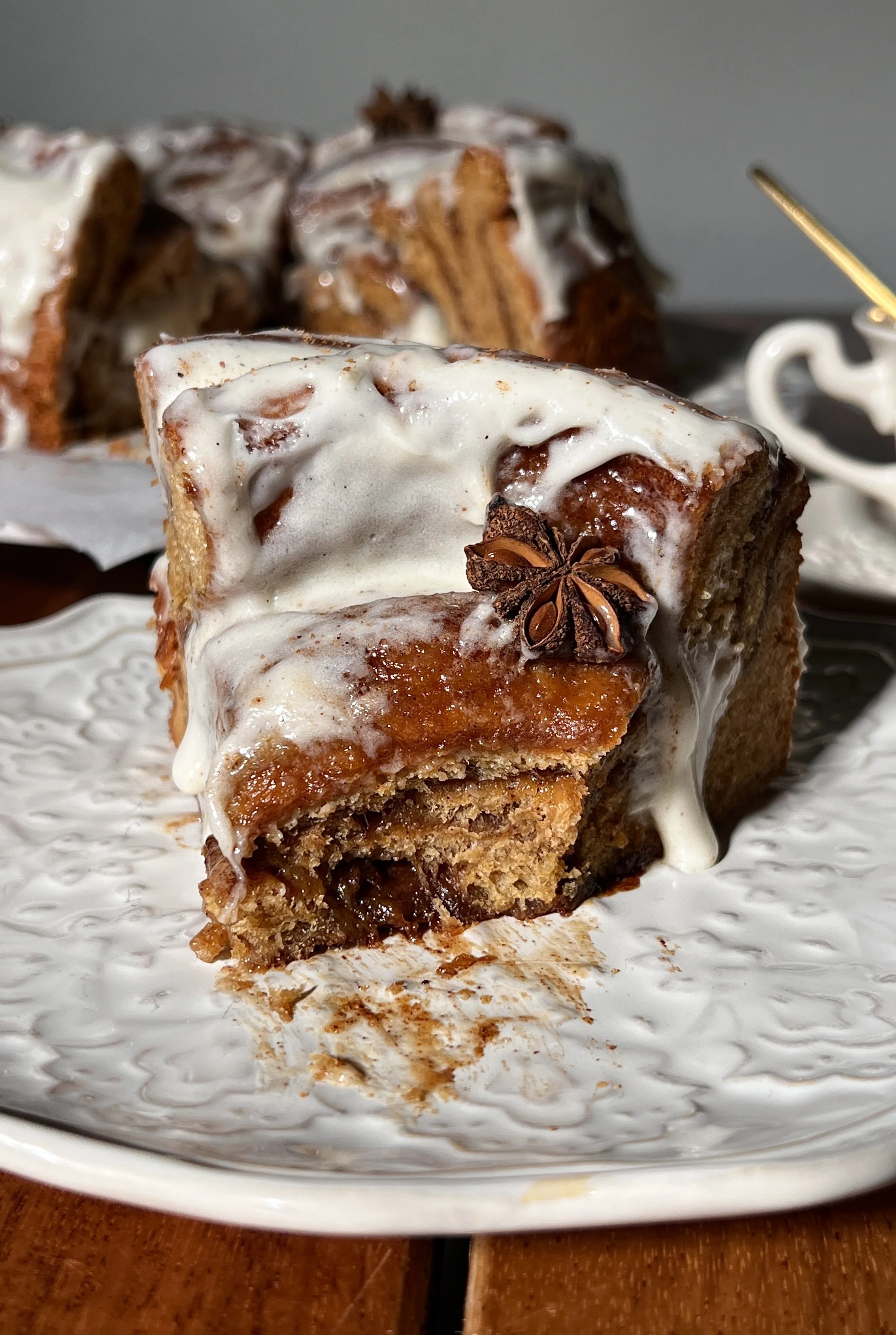 Close-up of a giant gingerbread cinnamon roll showing its soft, gooey center and cream cheese frosting.