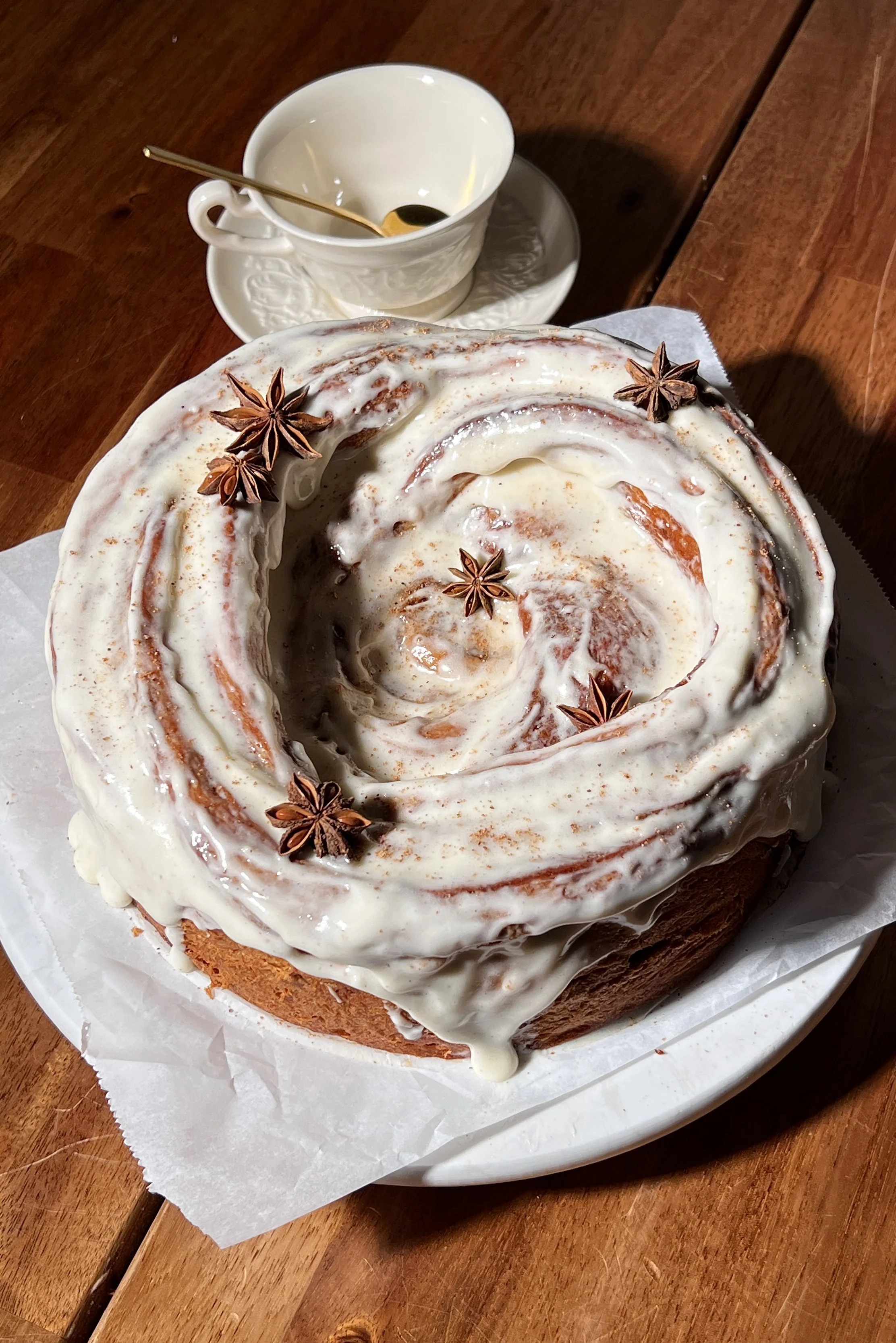 Close-up of a giant gingerbread cinnamon roll showing its soft, gooey center and cream cheese frosting.