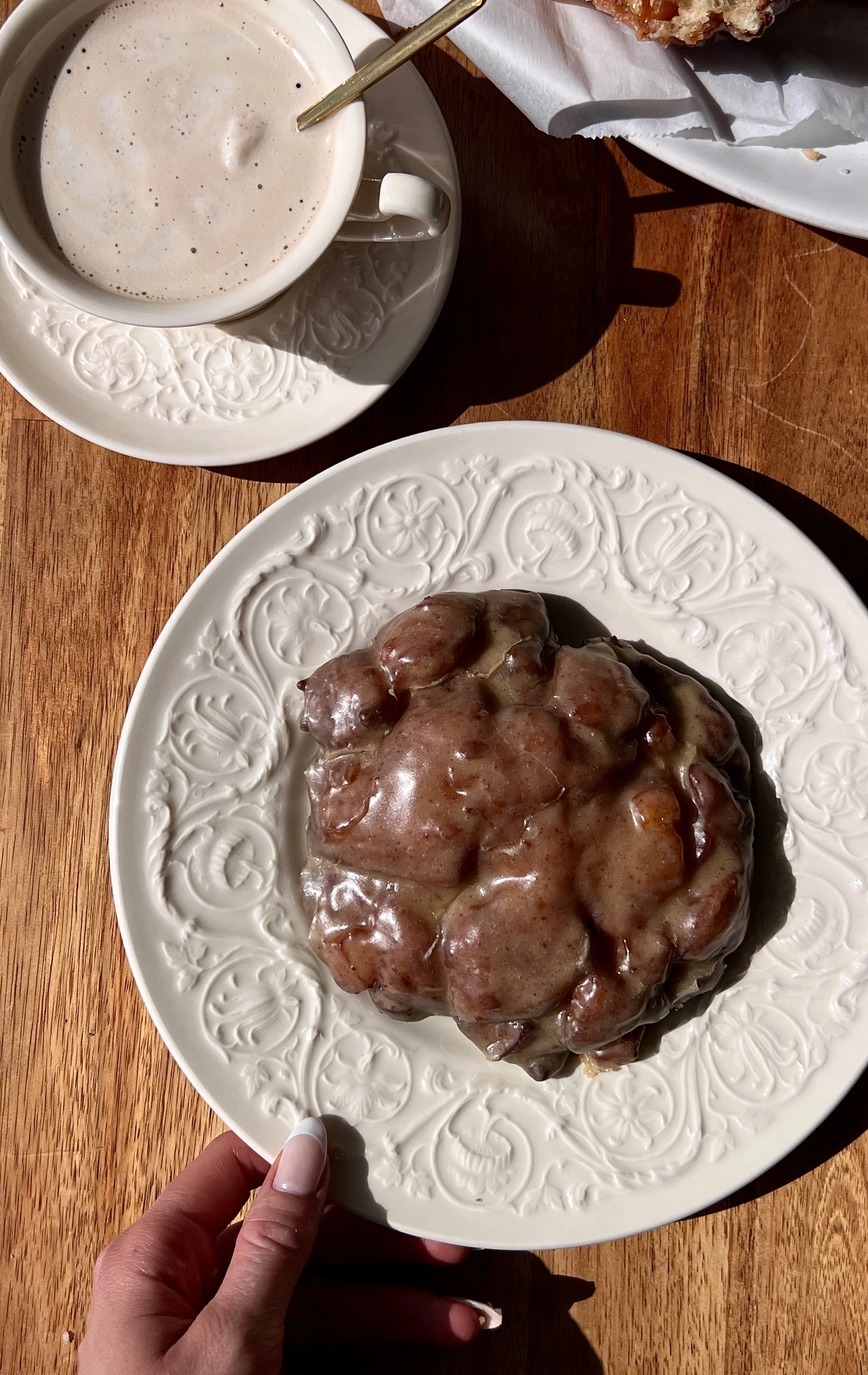 Soft and fluffy peach fritter donuts with a perfectly golden and crisp exterior and warm gooey peach filling throughout coated in a silky brown butter maple vanilla bean glaze served warm with a hot cup of coffee.