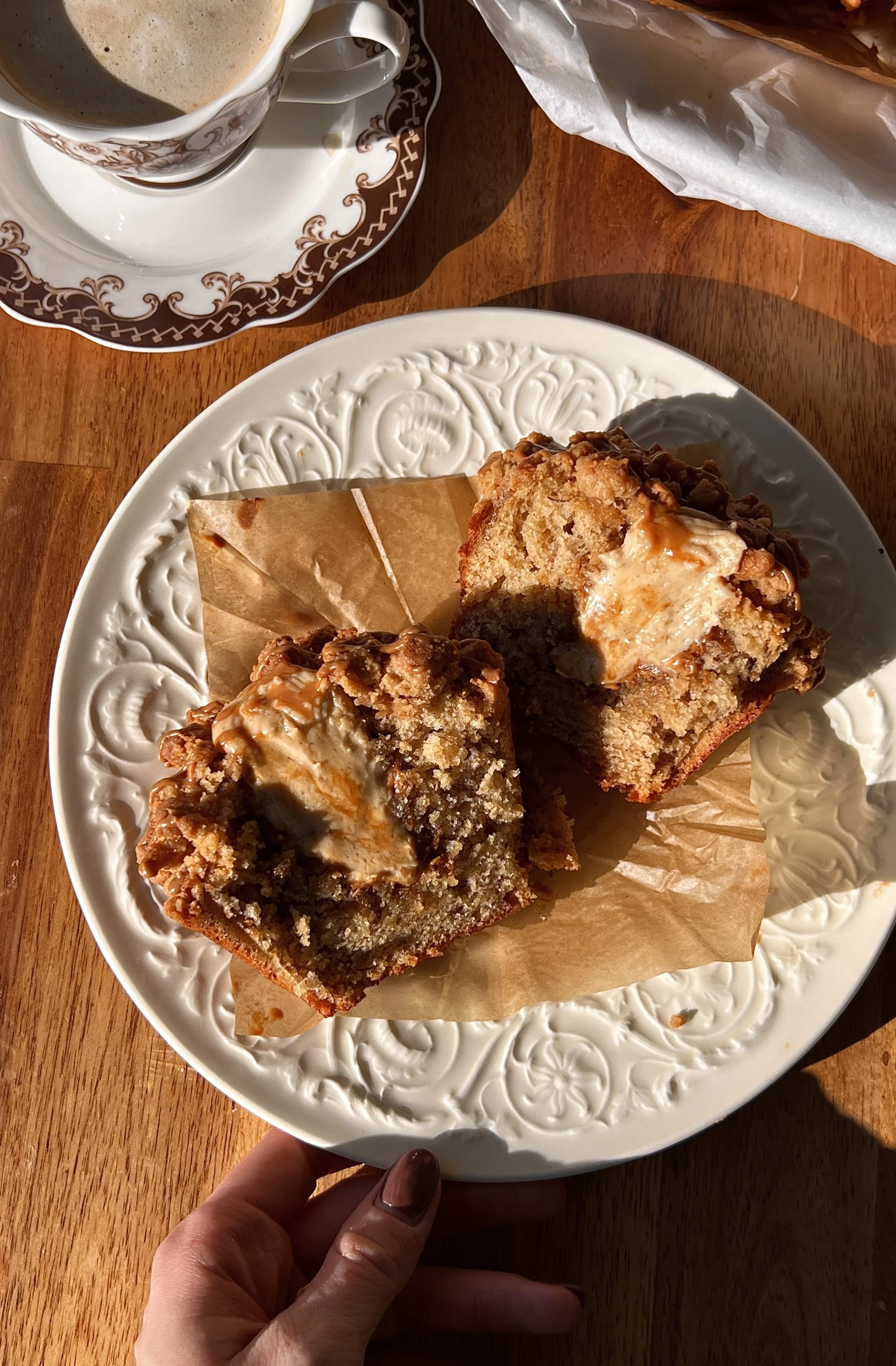 Soft and fluffy bakery-style banana Biscoff muffins with a rich Biscoff cream cheese filling and Biscoff cookie butter inside finished with a golden Biscoff streusel topping served warm with a hot cup of coffee.