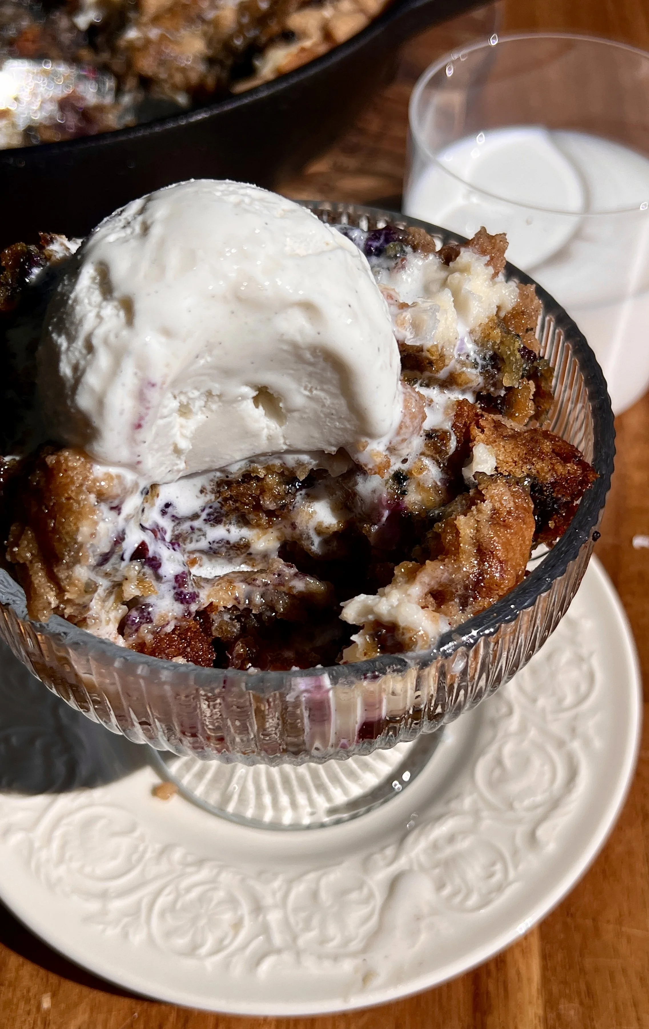 Warm brown butter blueberry crumble cookie skillet served with vanilla ice cream and flaky sea salt.