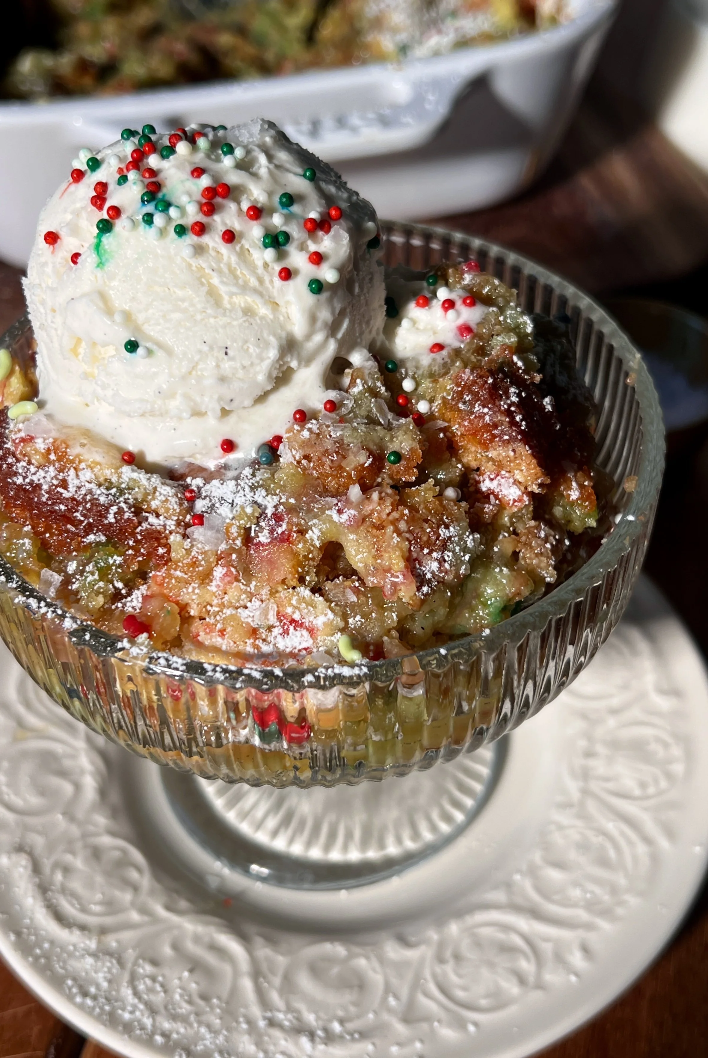 Warm slice of sugar cookie gooey butter cake with a soft sugar cookie base, a gooey cream cheese topping, a crackly golden surface, and a scoop of vanilla ice cream melting beside it.