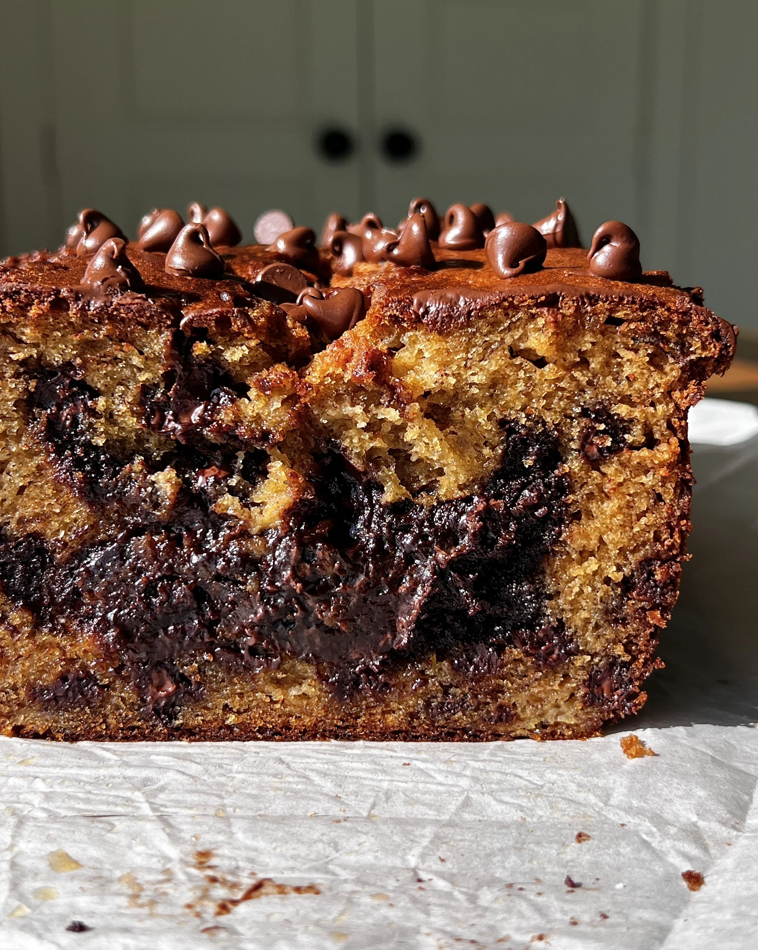 Close-up of a slice of brownie stuffed banana bread showing the soft fluffy banana bread exterior and rich fudgy brownie filling melting throughout.