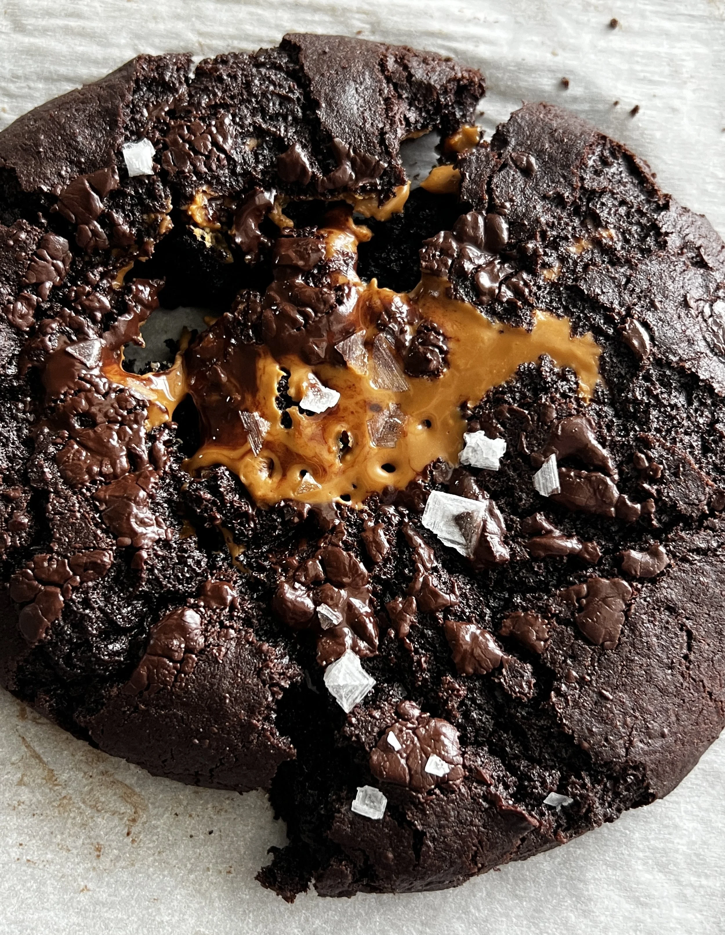 Close-up of two Giant Double Chocolate Chip Biscoff Cookies on a baking sheet. These oversized cookies are filled with creamy Biscoff cookie butter and studded with rich chocolate chips. With a crisp exterior and soft, gooey center, they're the perfe