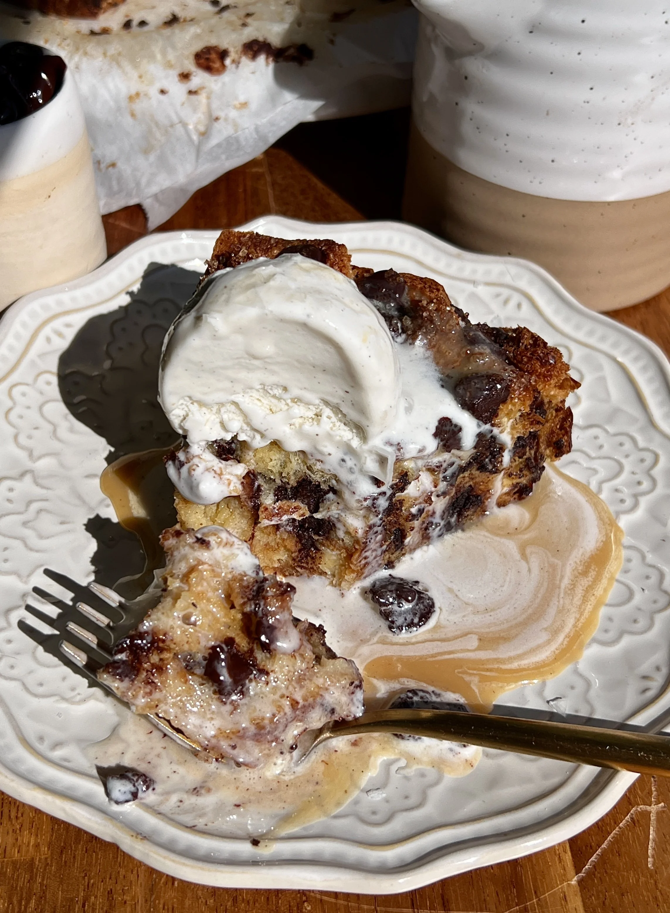 Warm chocolate chip bread pudding served with butter rum sauce, vanilla ice cream, and flaky sea salt.
