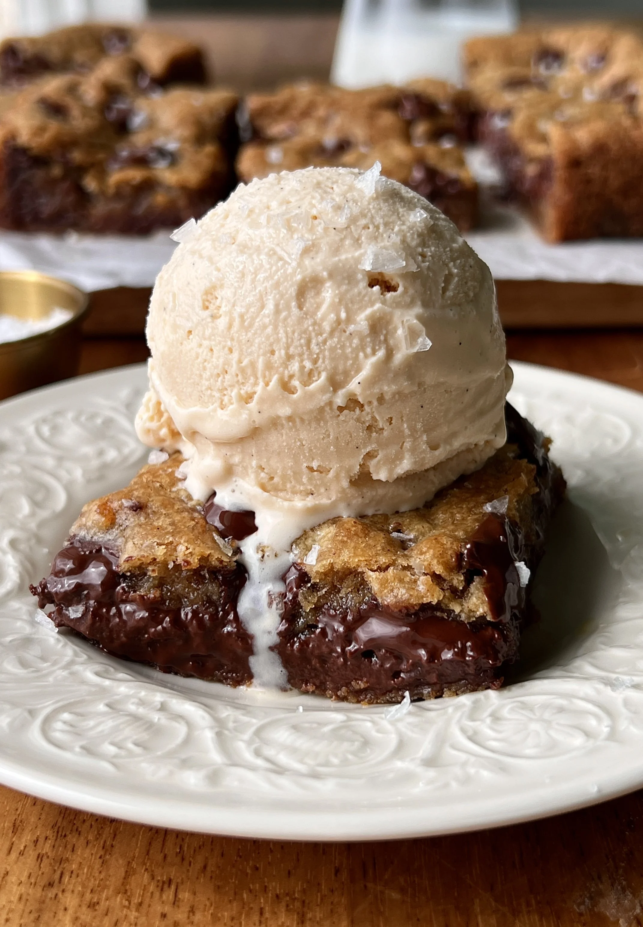 Soft and gooey brown butter banana bread chocolate chip cookie bars with perfectly crisp and golden edges and melty chocolate chips throughout served warm with a scoop of vanilla ice cream as the ultimate cozy treat.