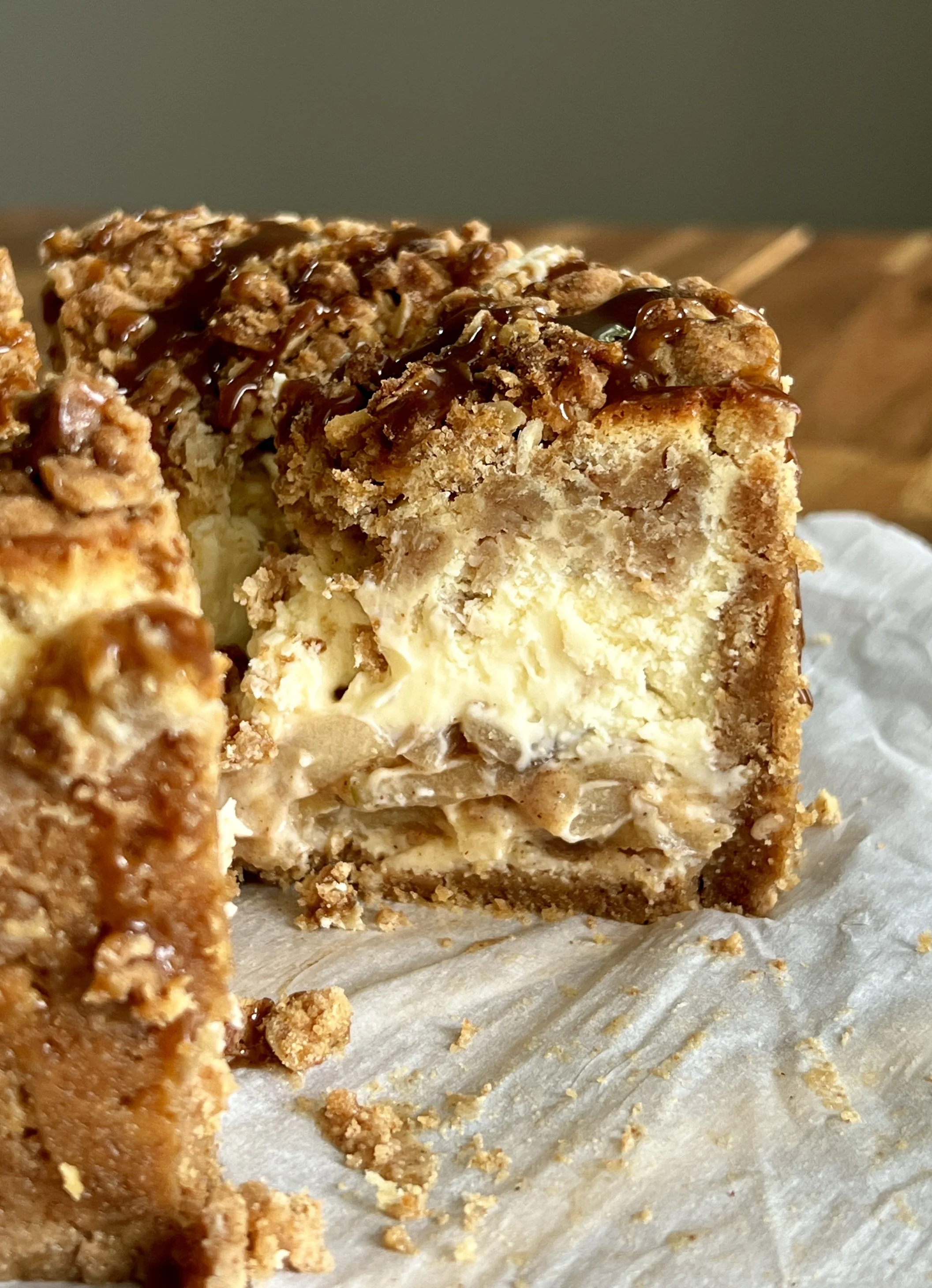 6-inch mini apple crumble cheesecake with a graham cracker crust, apple pie filling, and finished with a drizzle of salted caramel.