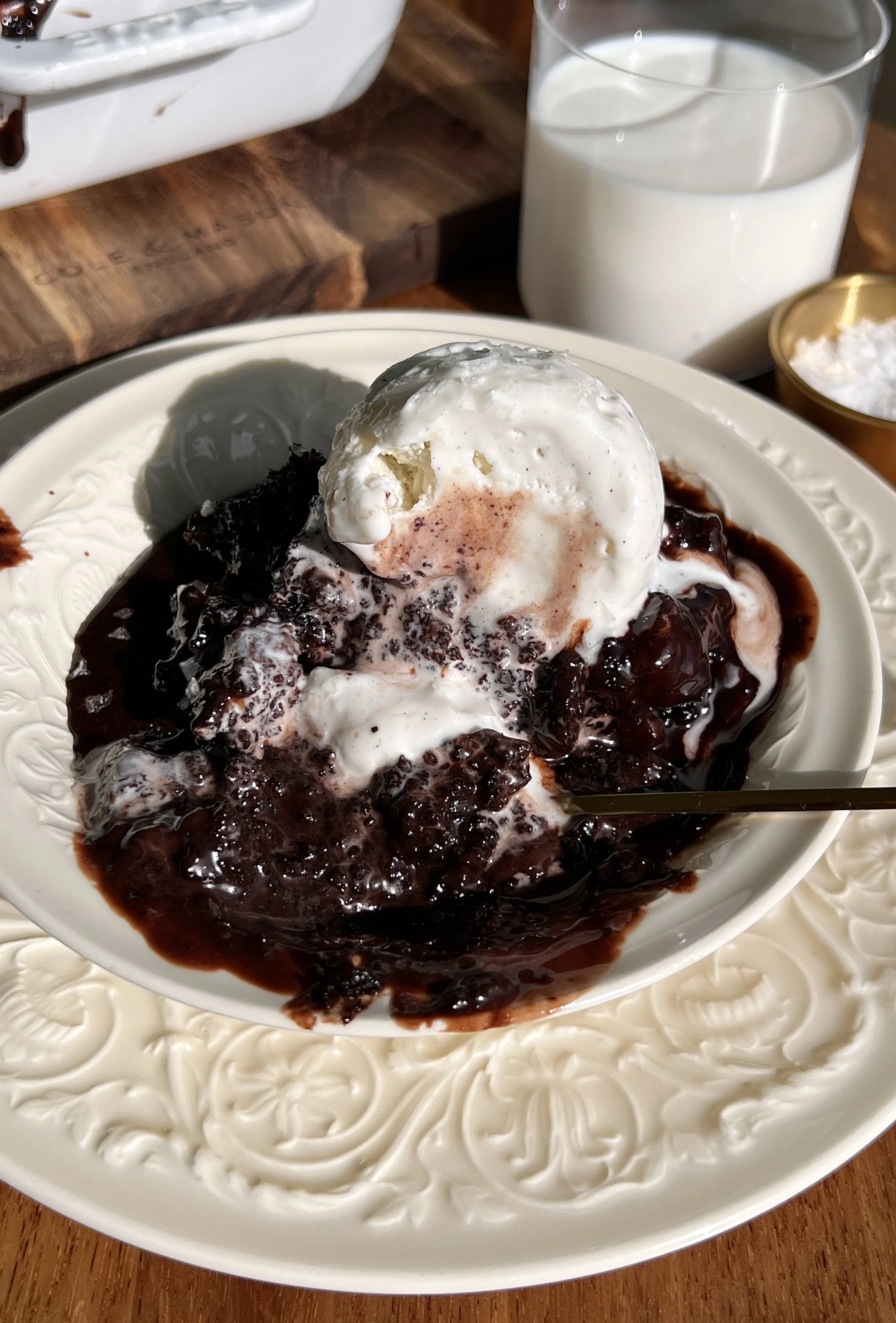 Warm hot chocolate fudge cake served with chocolate ganache, vanilla ice cream, and flaky sea salt.