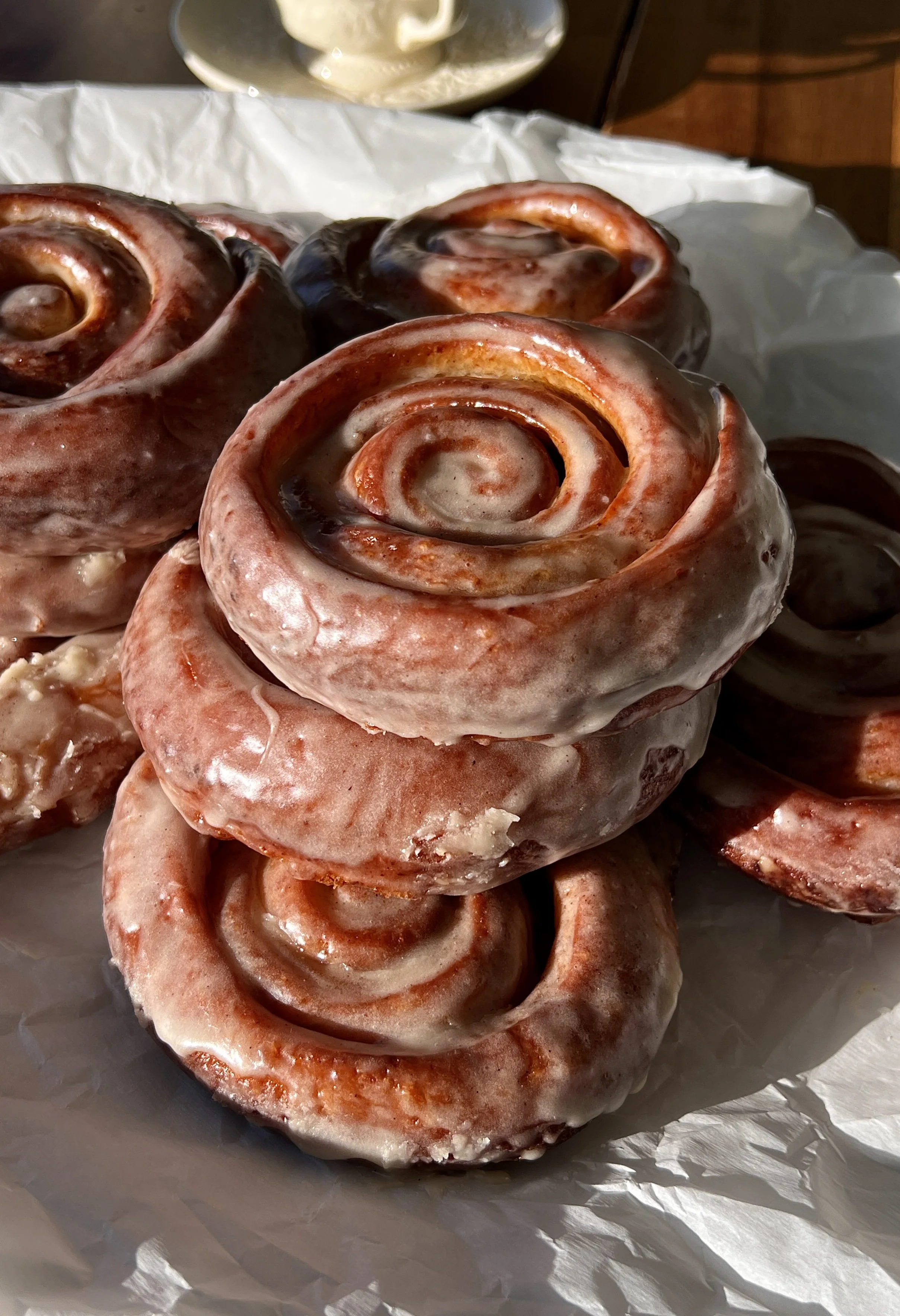 Homemade honey buns glazed with silky honey icing and served warm with a cup of coffee.