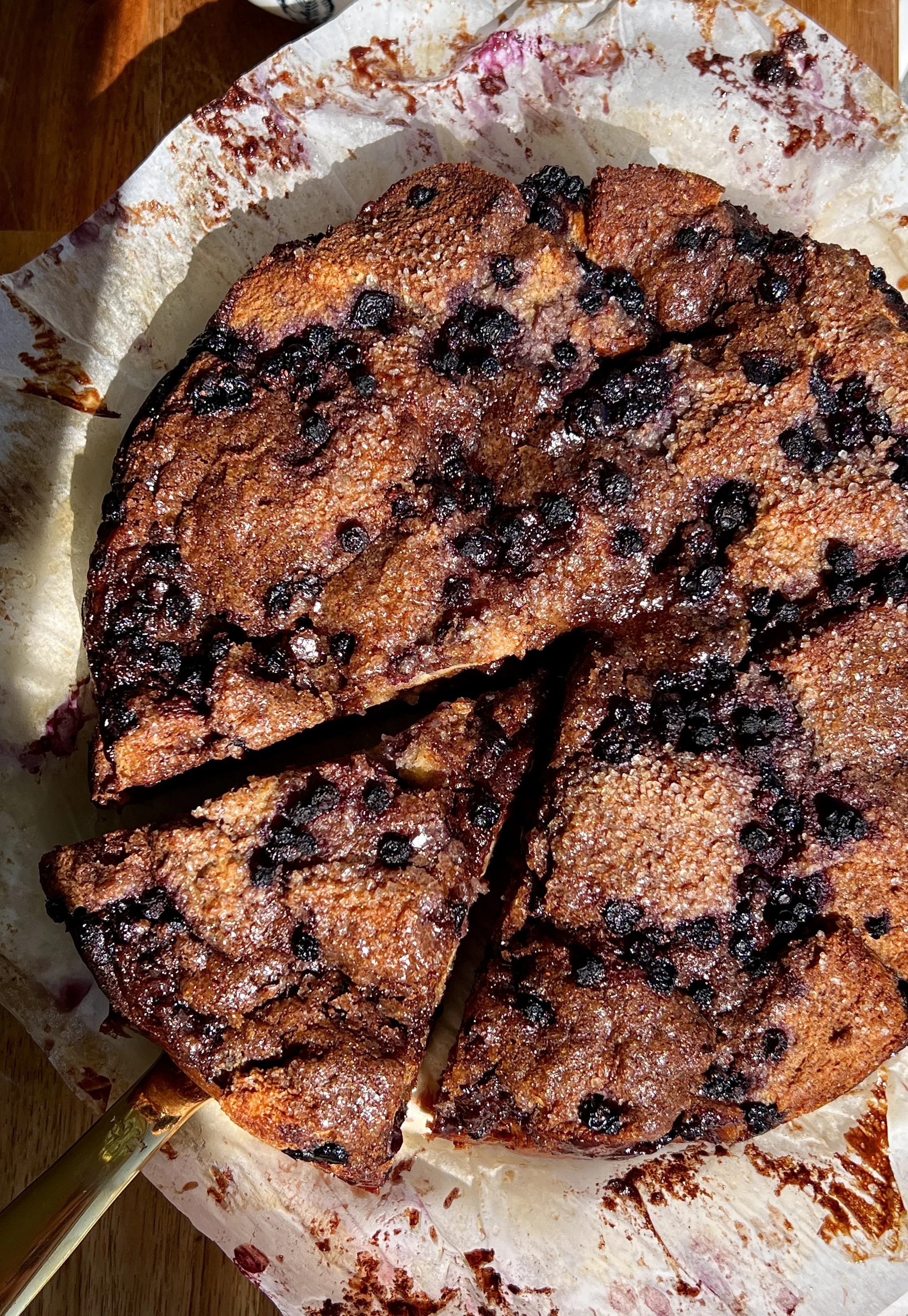 Close-up of blueberry cinnamon roll bread pudding with bright blueberries and a gooey brown sugar cinnamon swirl throughout.