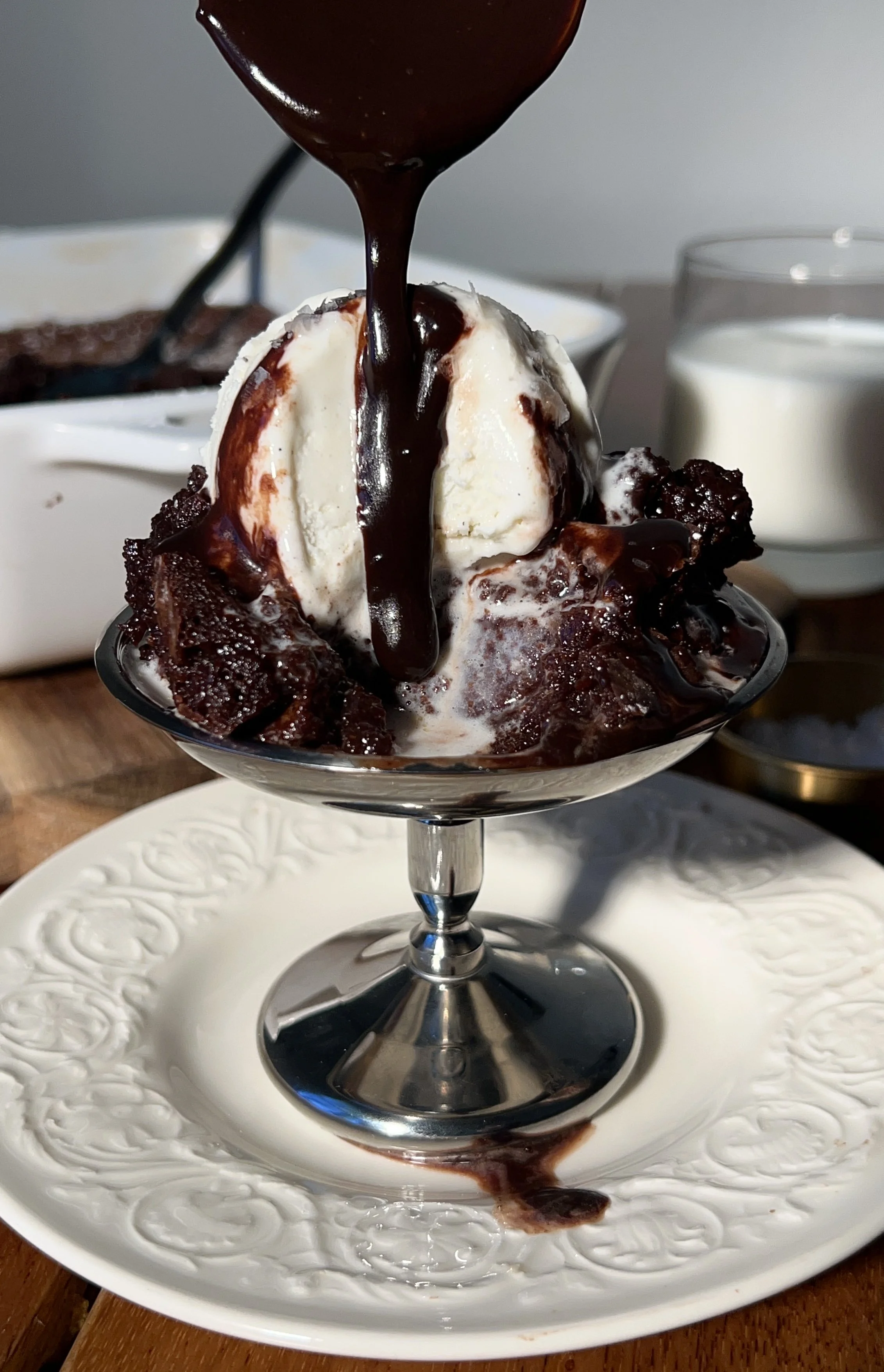 Warm deep dish brown butter molten lava cake with a gooey chocolate center, topped with vanilla ice cream and hot fudge.