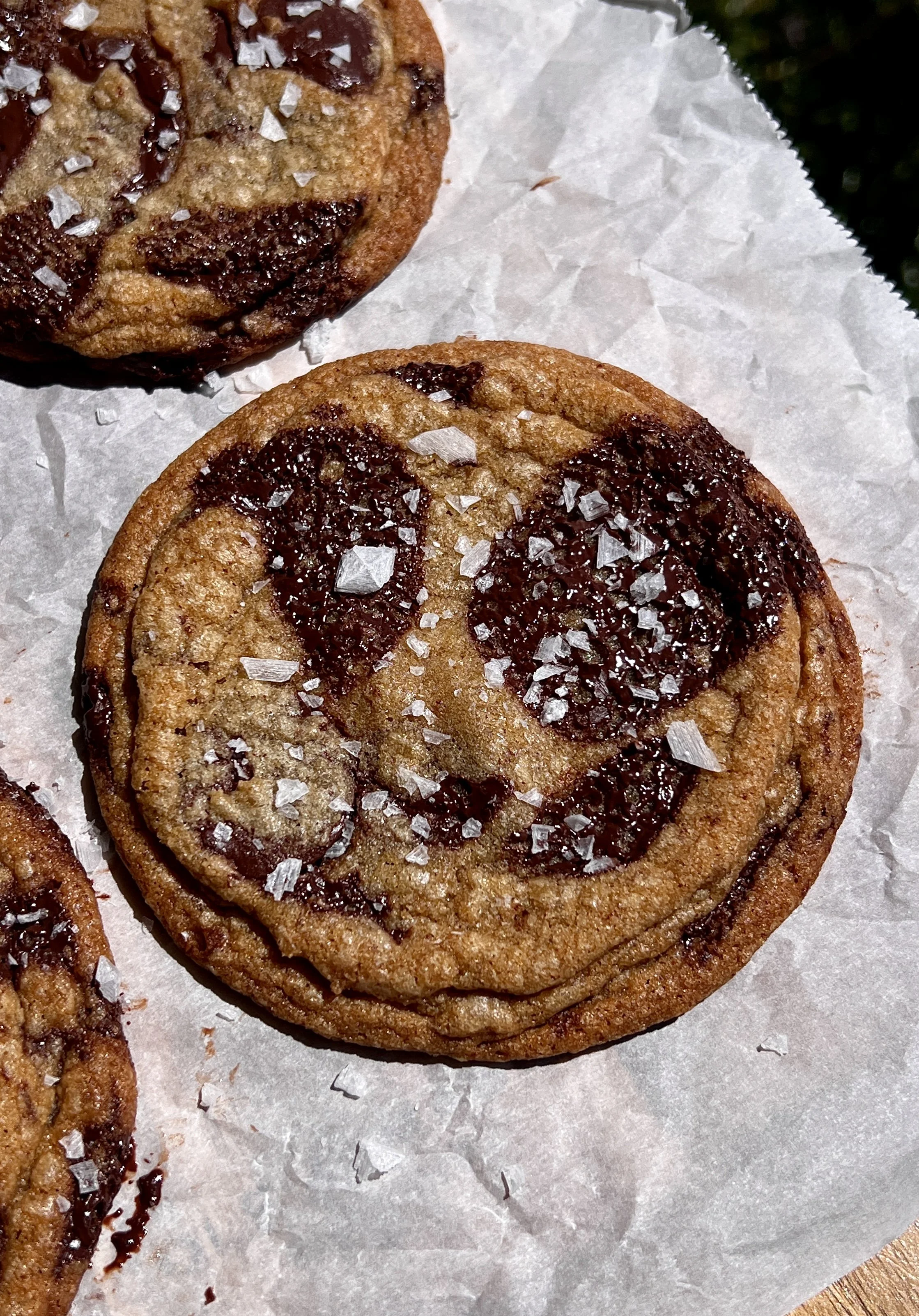 Crinkled brown butter chocolate chip cookies topped with flaky sea salt and served warm.