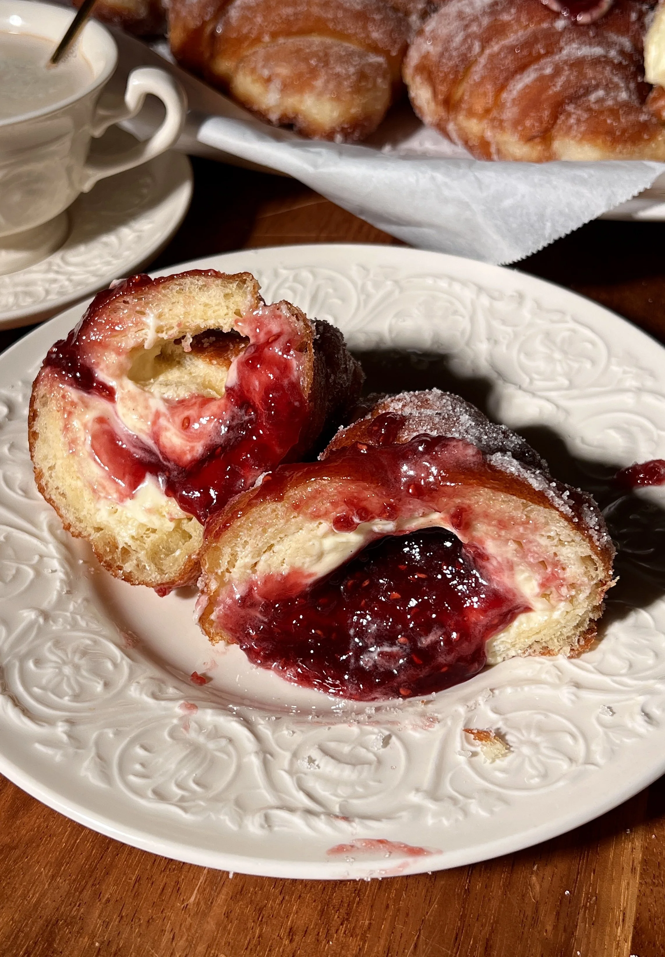 Croissant-shaped doughnuts filled with vanilla bean custard and raspberry jam, rolled in sugar and fried until golden.