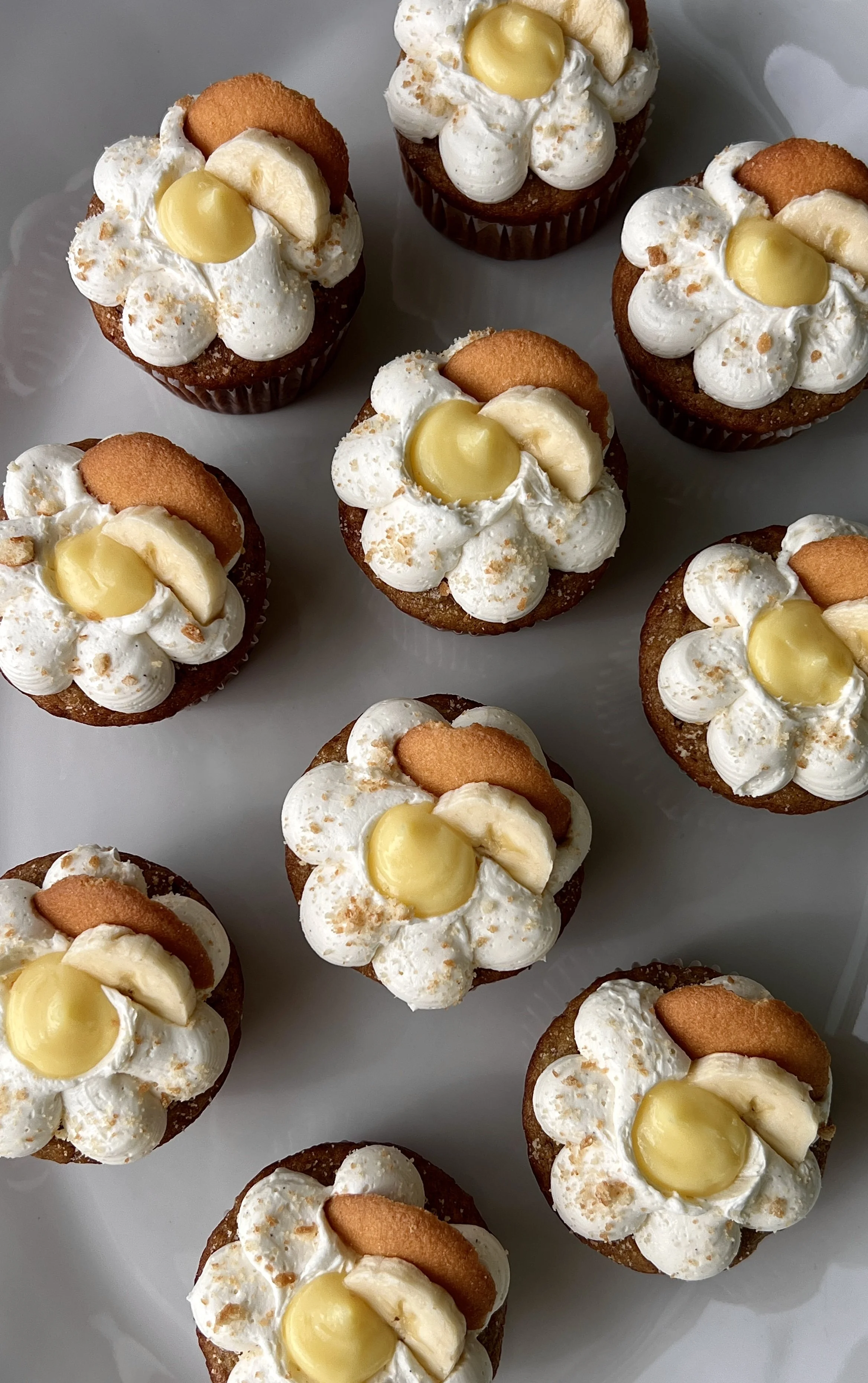 Close-up of a brown butter banana pudding cupcake filled with classic vanilla pudding and topped with light and fluffy whipped buttercream and crushed Nilla wafers.
