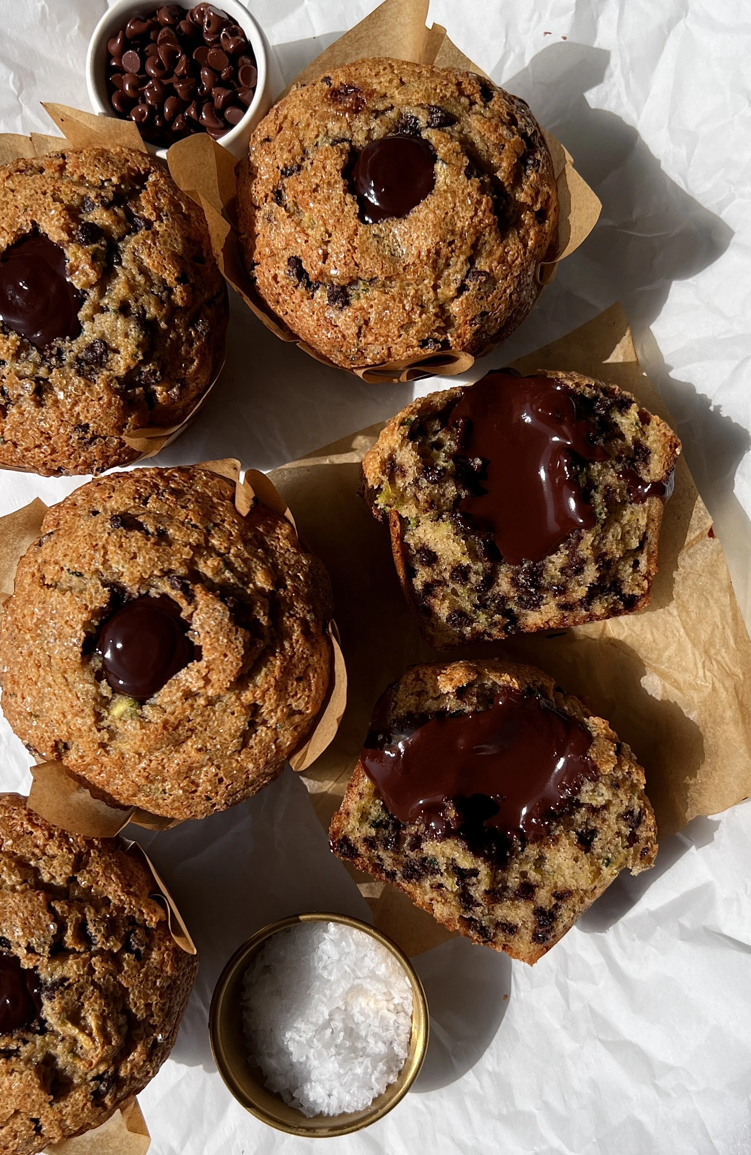 Close-up of a bakery-style chocolate fudge zucchini muffin with a soft and fluffy tender crumb, melty chocolate chips throughout, and a warm molten chocolate ganache center.