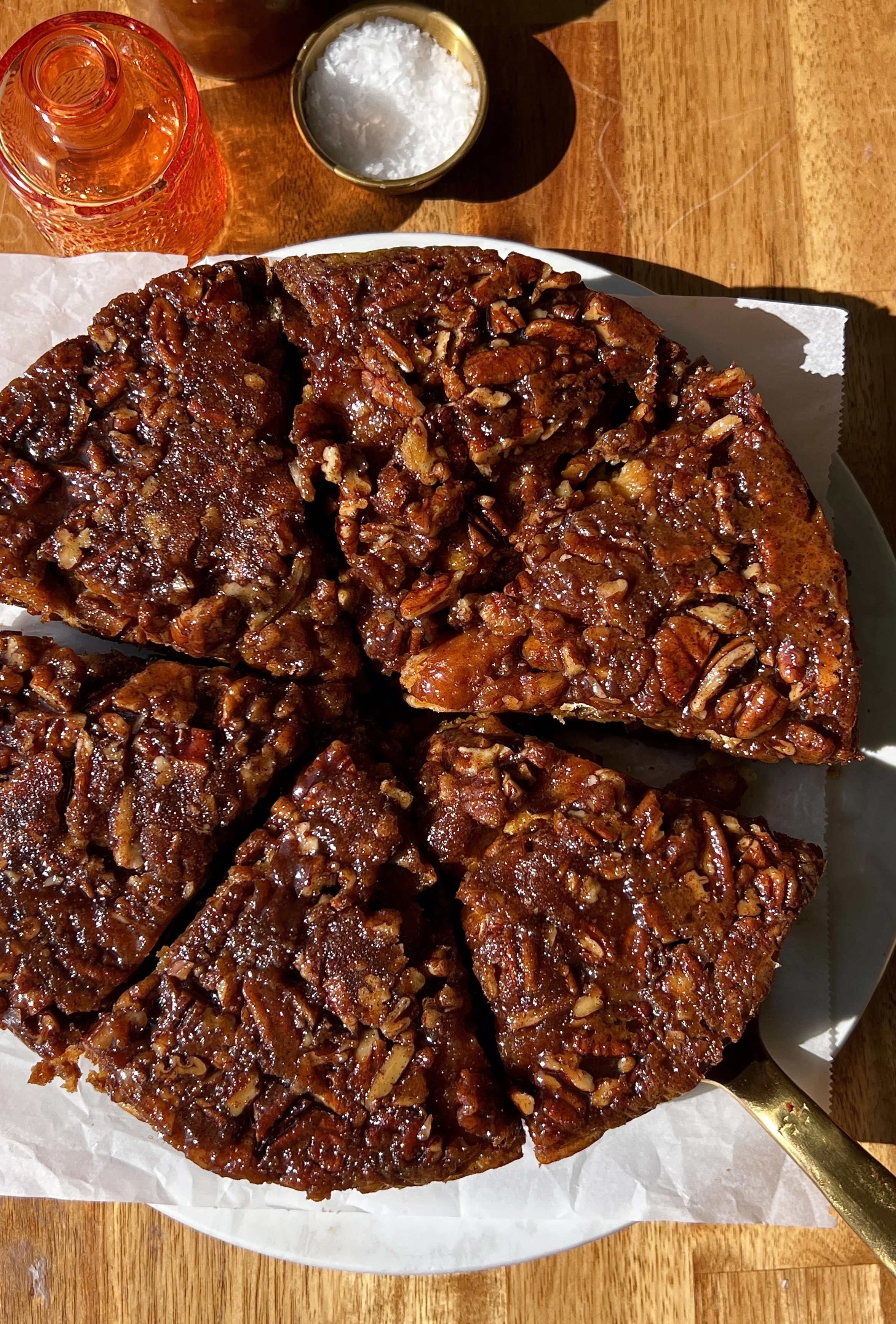 Close-up of pecan sticky bun pumpkin bread pudding showing the soft buttery brioche soaked in spiced pumpkin custard with a warming gooey sticky pecan filling swirled and layered throughout.