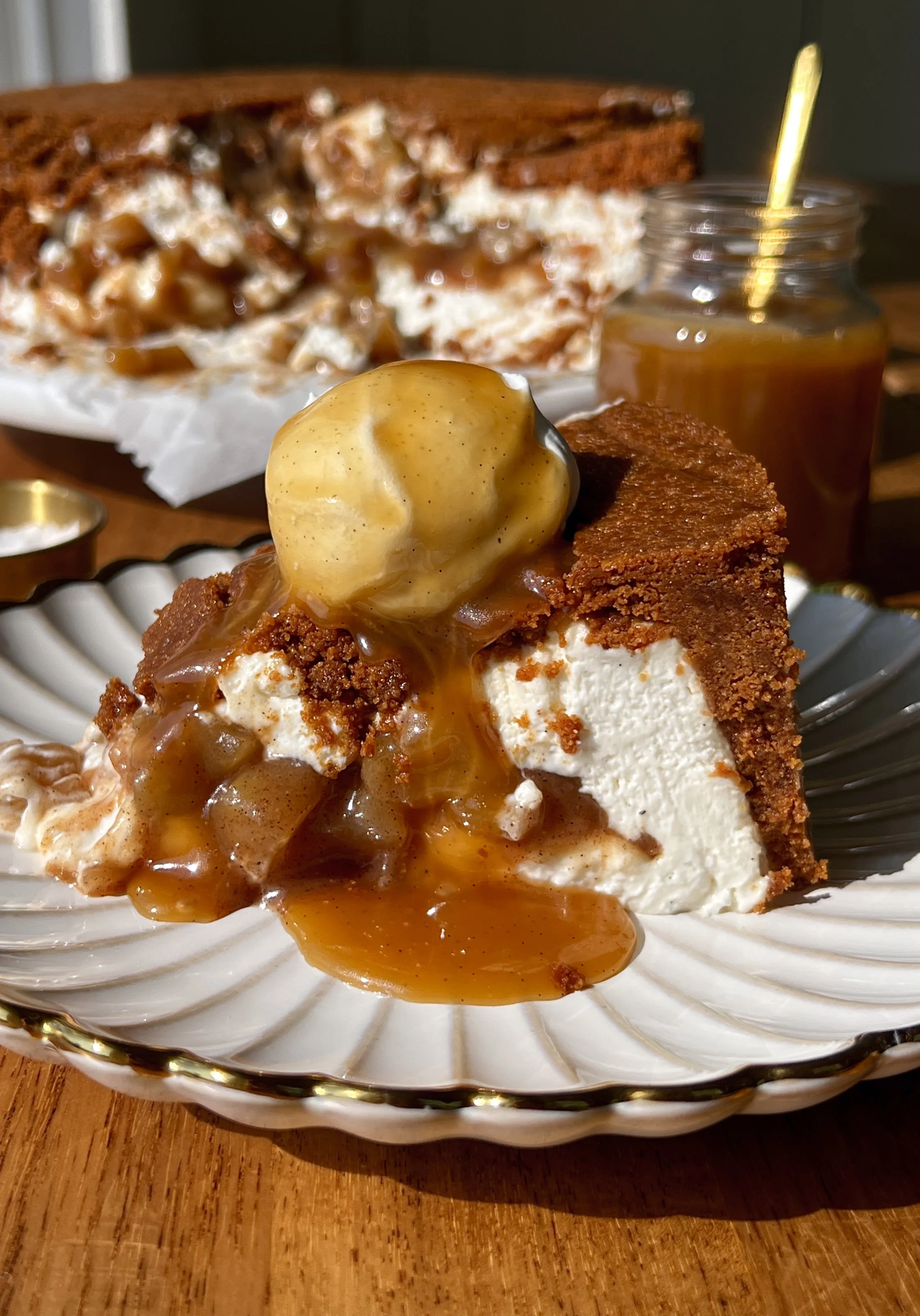Upside down apple pie no-bake cheesecake with a buttery Biscoff cookie crust on top inverted to serve and finished with a brown sugar salted caramel drizzle as the ultimate fun and impressive fall no-bake dessert.