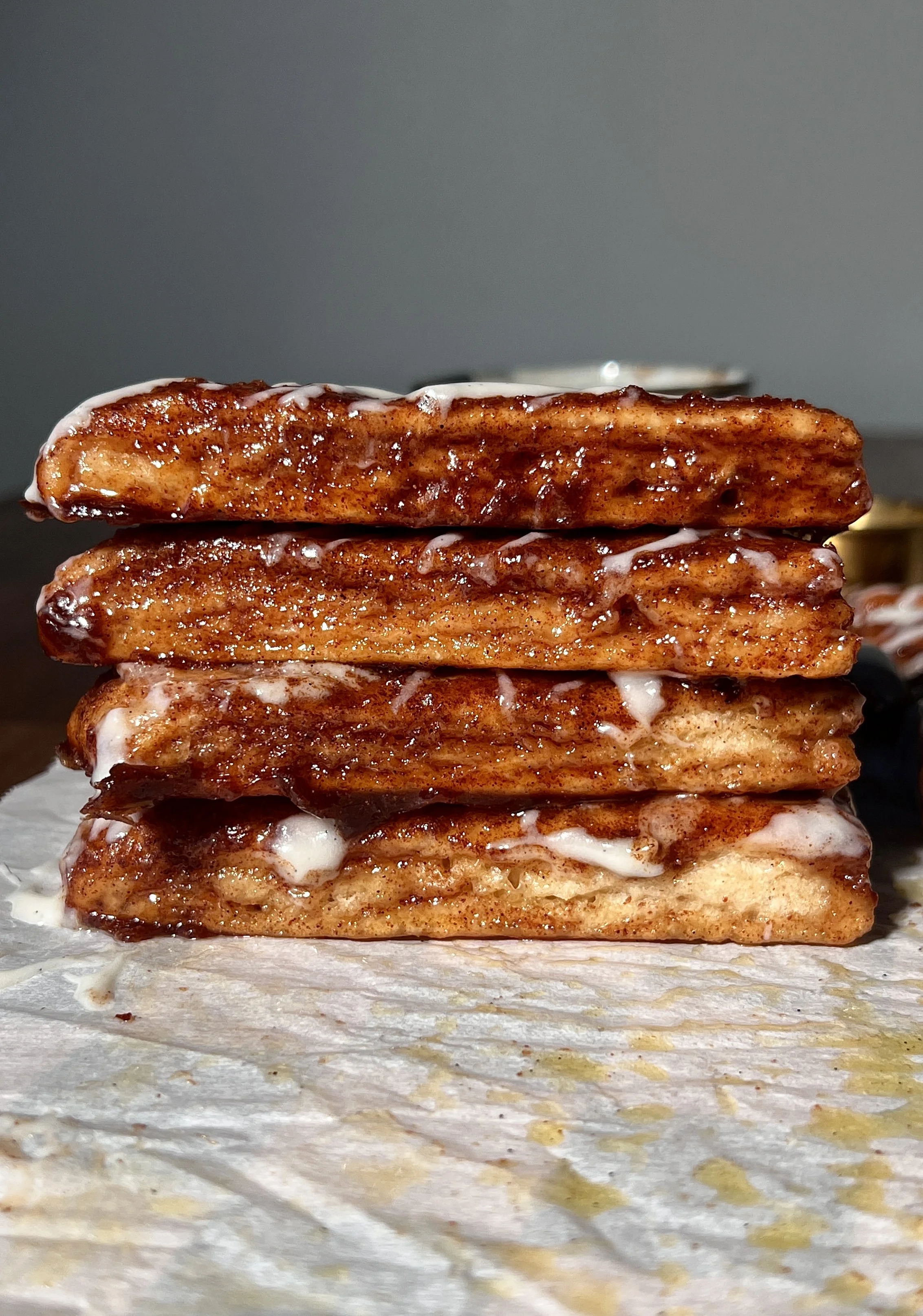 Soft and fluffy sourdough cinnasticks made with sourdough discard and Greek yogurt dough, topped with gooey cinnamon sugar and drizzled with a tangy cream cheese glaze, served warm.
