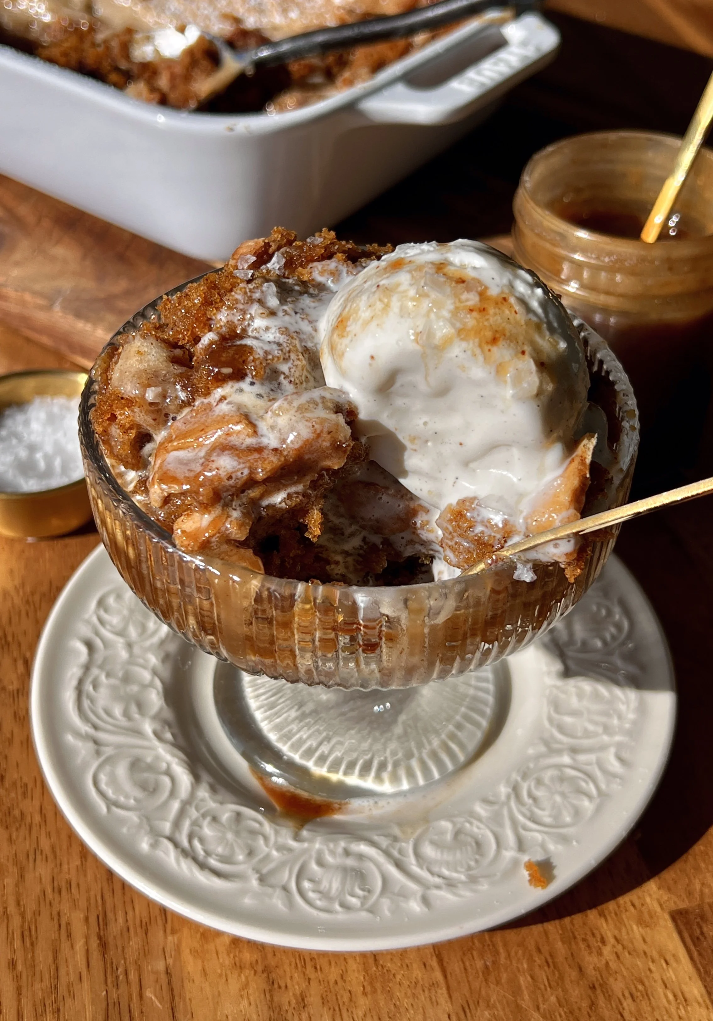 Warm and cozy deep dish sweet potato gooey brown butter cake with a perfectly crackly cinnamon cream cheese top served with a scoop of vanilla ice cream, a drizzle of salted caramel, and a sprinkle of flaky sea salt.