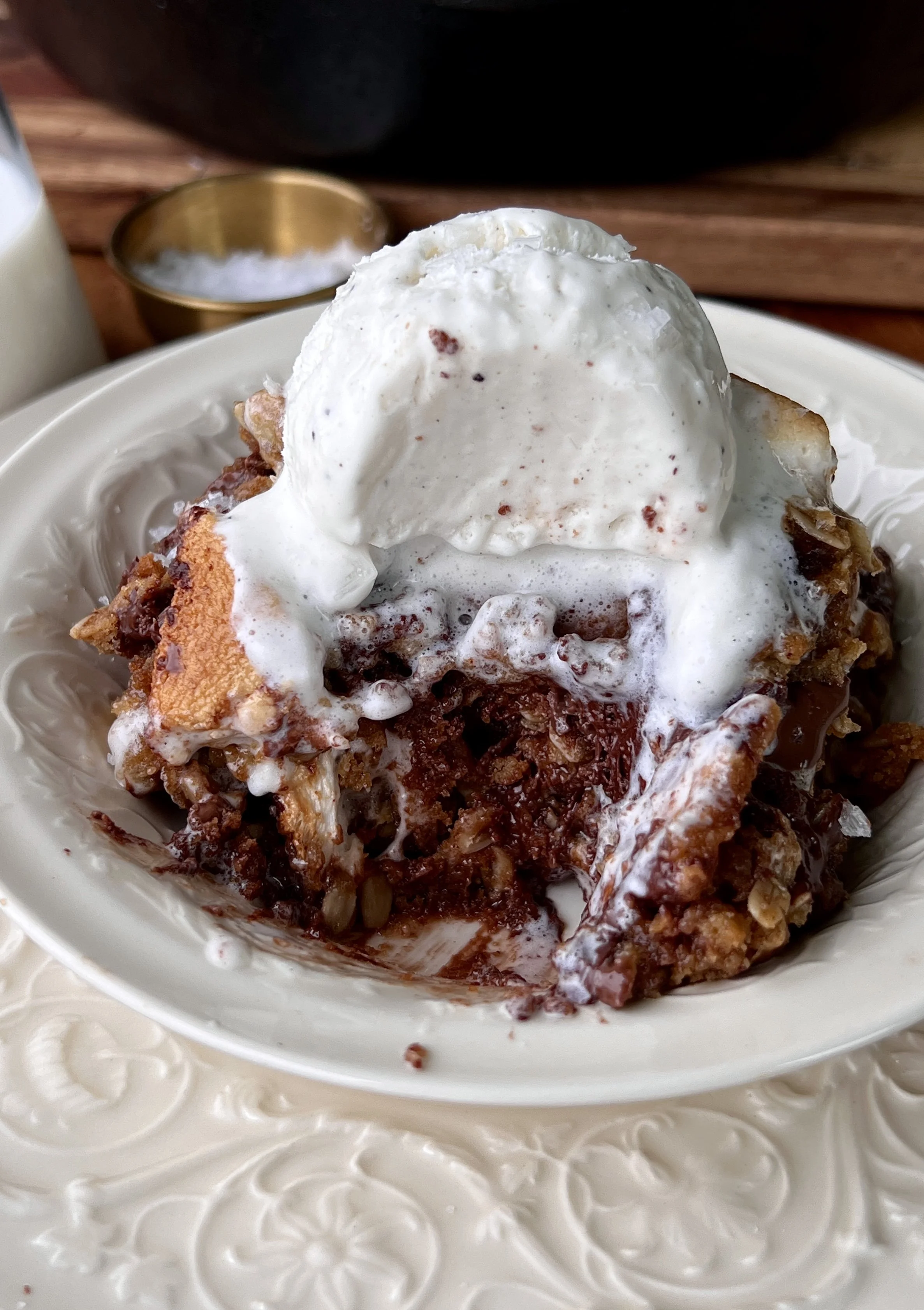 Soft and gooey peanut butter s'mores oatmeal cookie skillet made with brown butter, melty chocolate, toasted marshmallows, and crushed graham crackers served warm with a scoop of vanilla ice cream and flaky sea salt.
