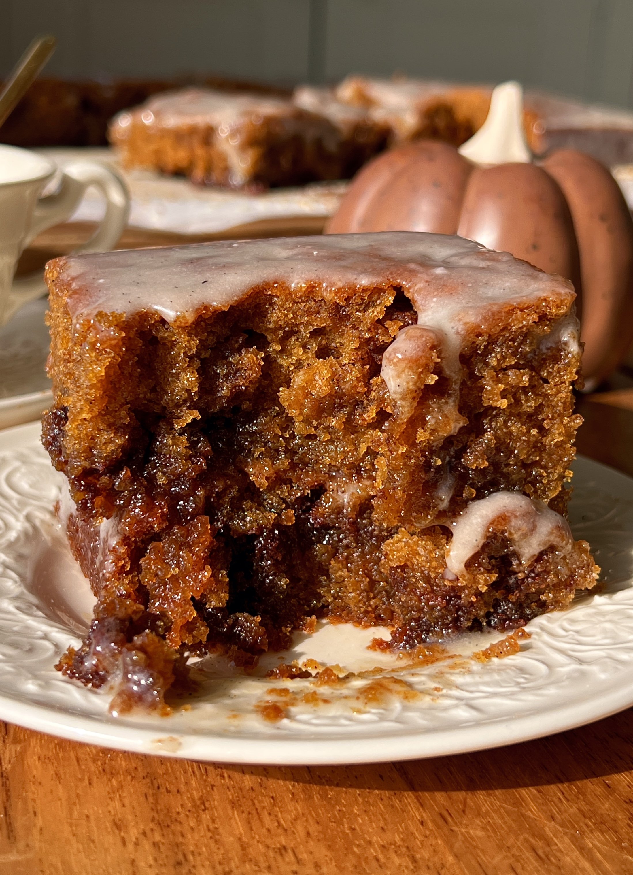 Close-up of a pumpkin honey bun cake showing the soft and tender delicate spiced pumpkin crumb with a cinnamon brown sugar swirl throughout and honey cream cheese glaze melting over the top.