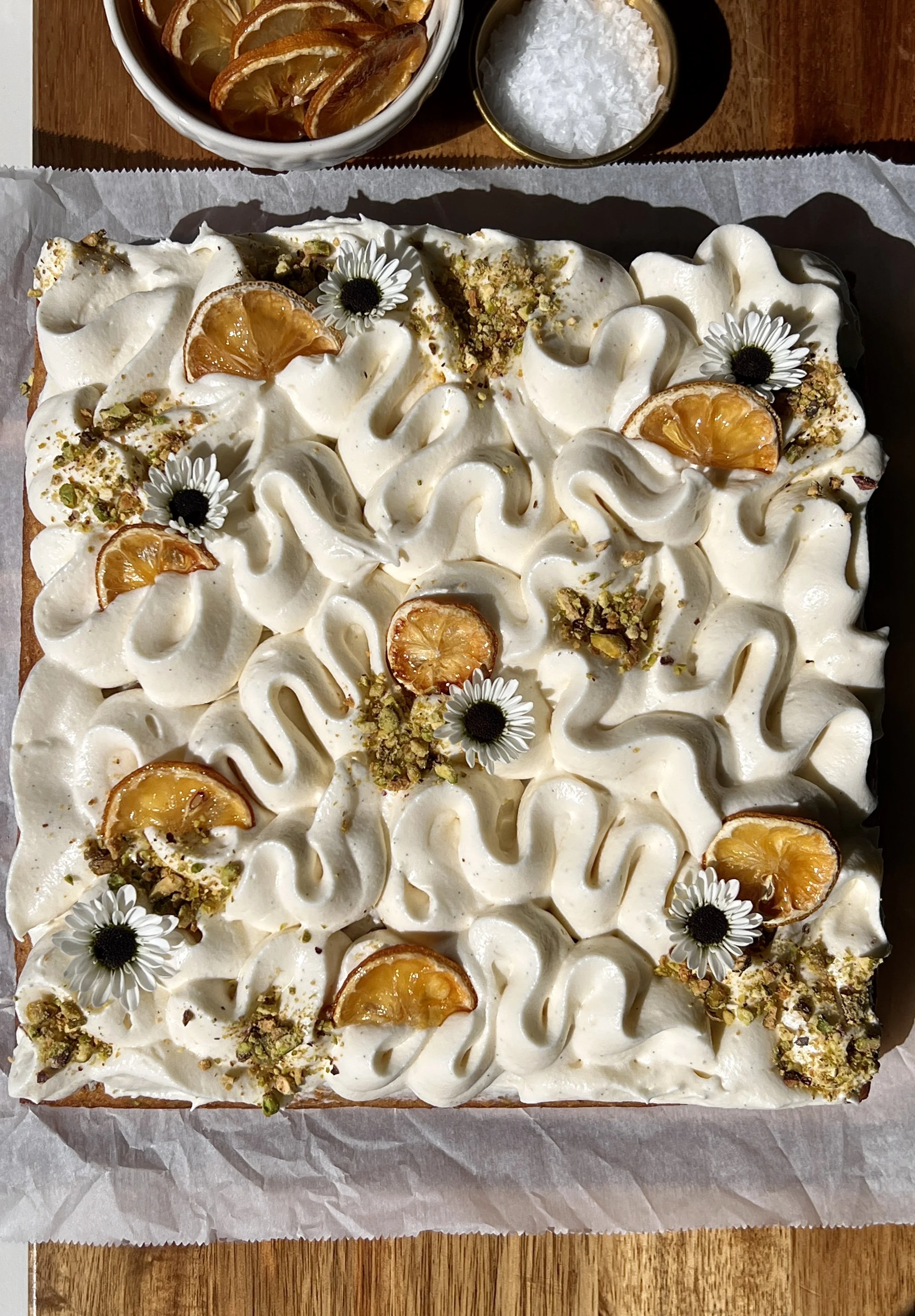 Lemon curd pistachio cake with cream cheese frosting and chopped pistachios on top.