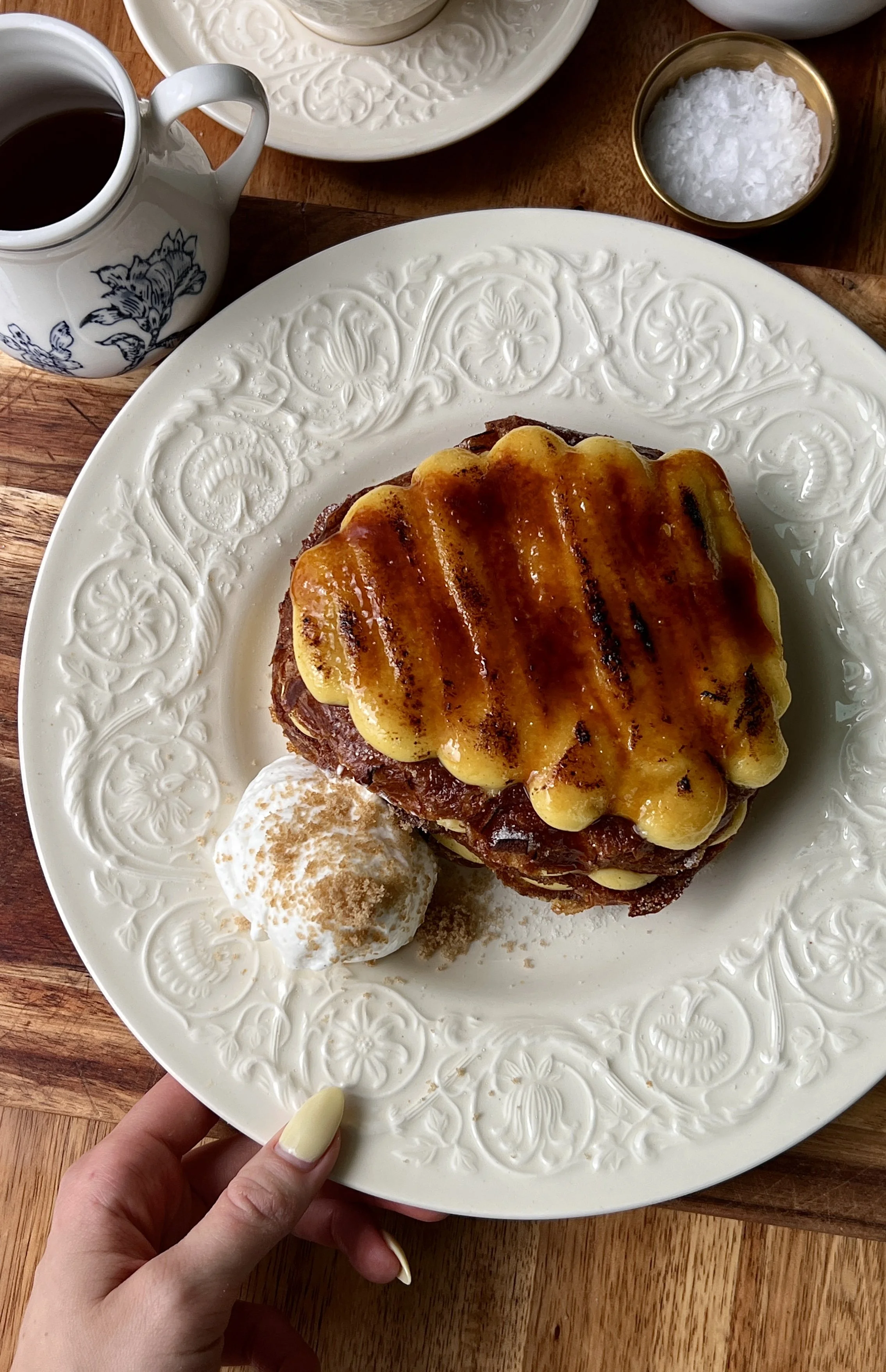 Soft and buttery crème brûlée croissant french toast pan-fried until perfectly golden with a thick vanilla bean custard and crisp caramelized sugar topping served with maple syrup, whipped cream, and a hot cup of coffee.