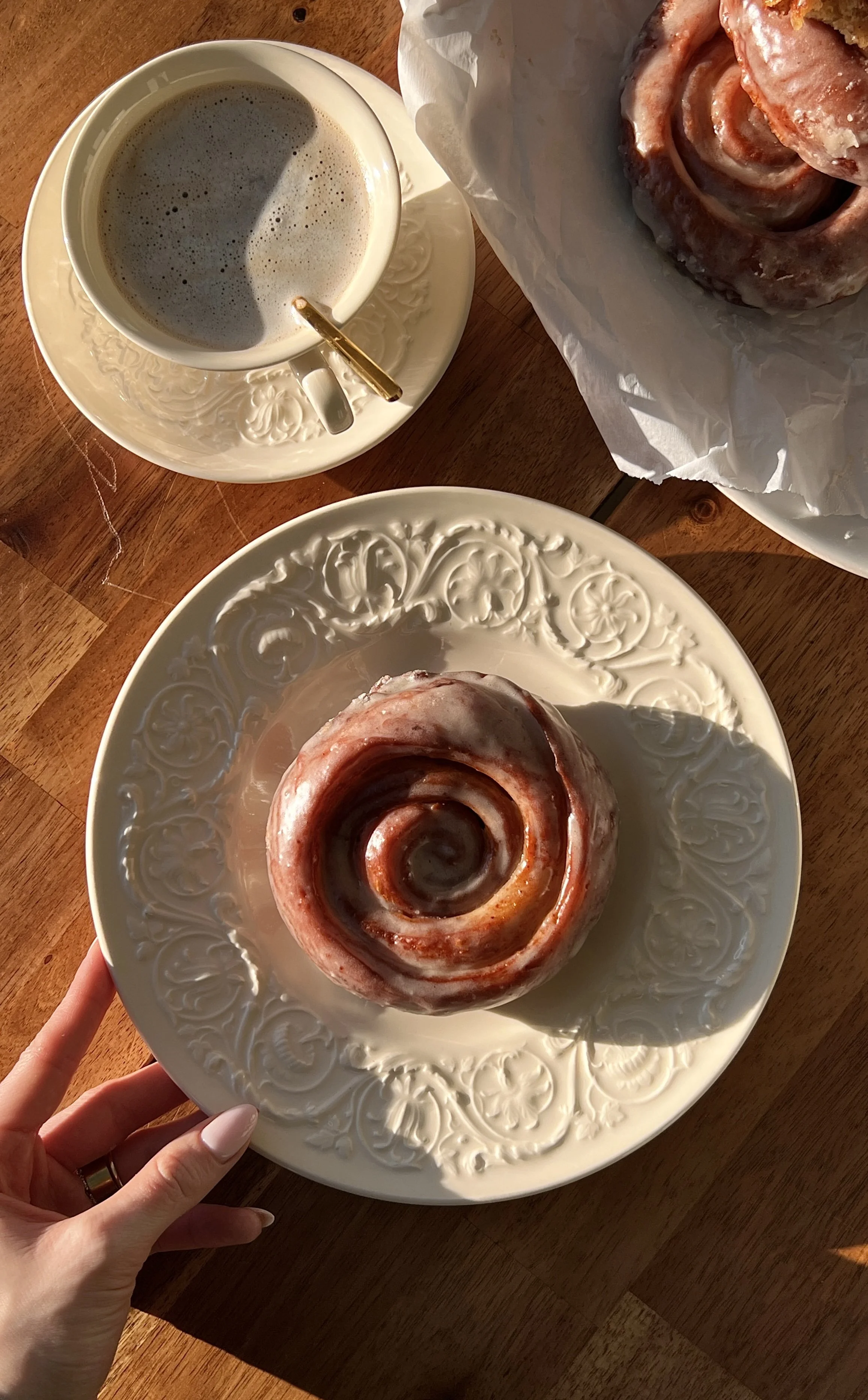 Warm glazed homemade honey buns with honey butter cinnamon swirls served with hot coffee.