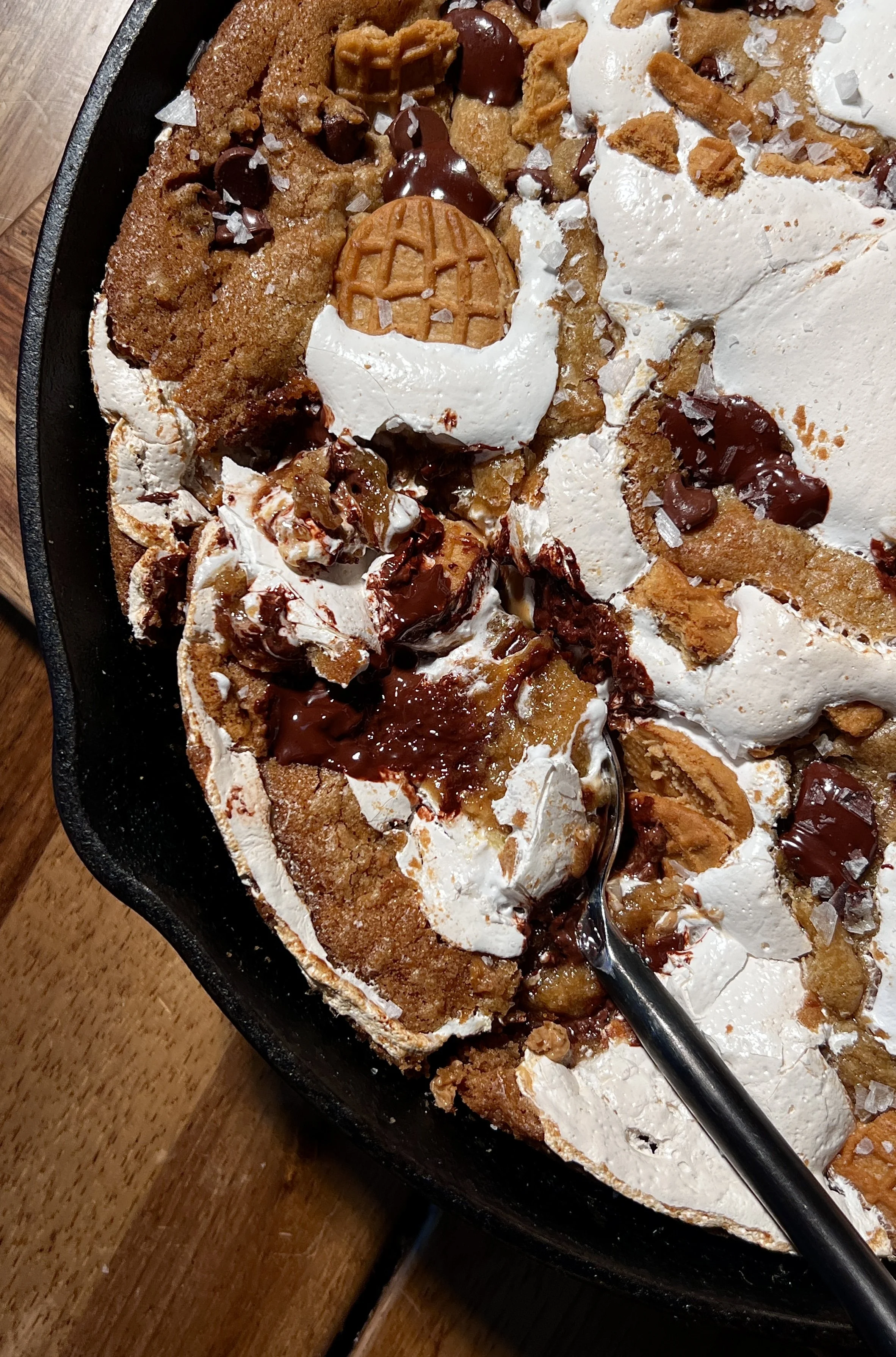 Fluffernutter chocolate chip cookie skillet with brown butter, featuring a gooey center, golden crisp edges, melty chocolate chips, peanut butter, marshmallow fluff, crushed Nutter Butter cookies, and vanilla ice cream on top.