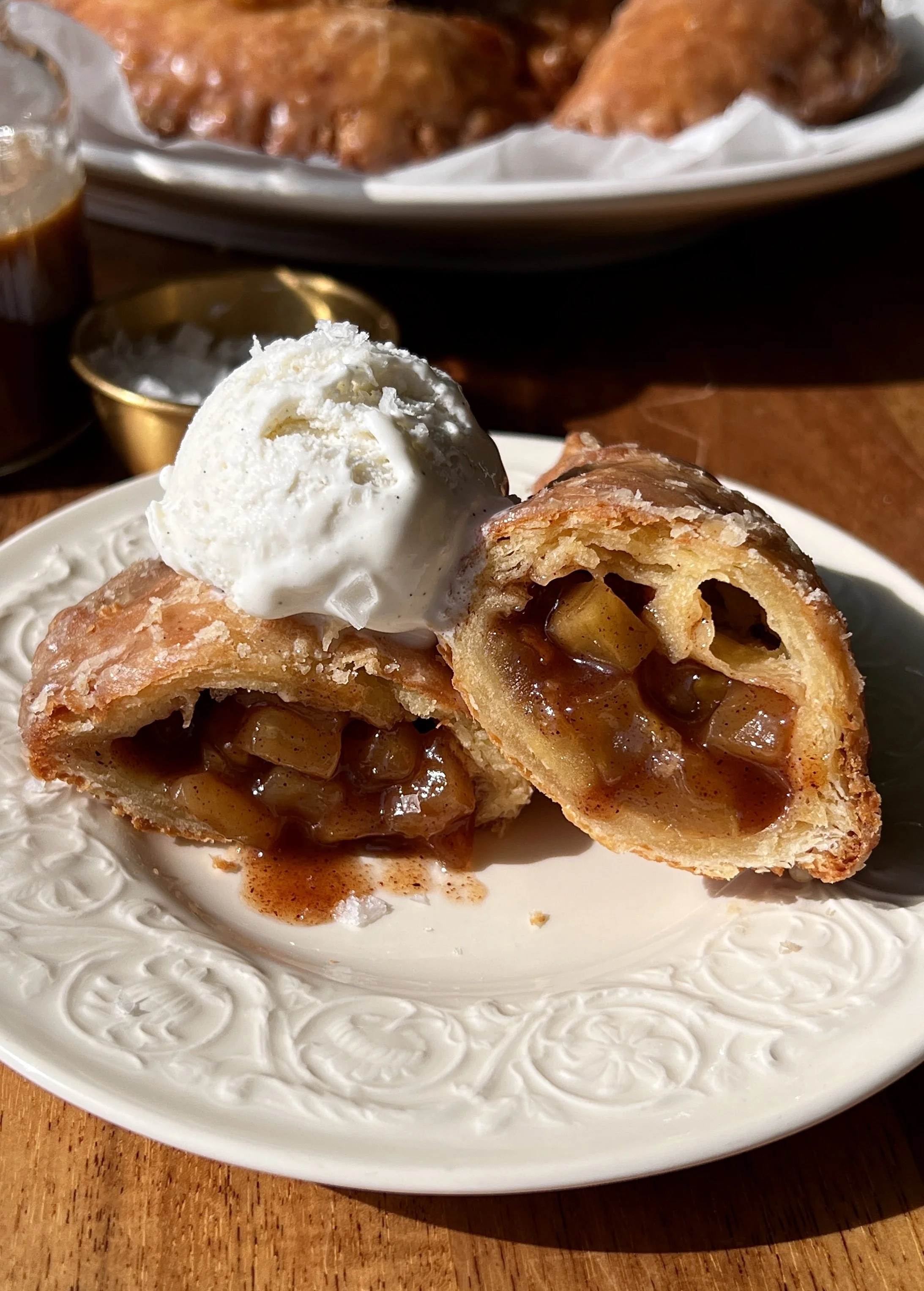 Golden flaky and buttery fried apple hand pies stuffed with warm and gooey spiced apple pie filling finished with a silky brown butter maple vanilla bean glaze melting over the top.