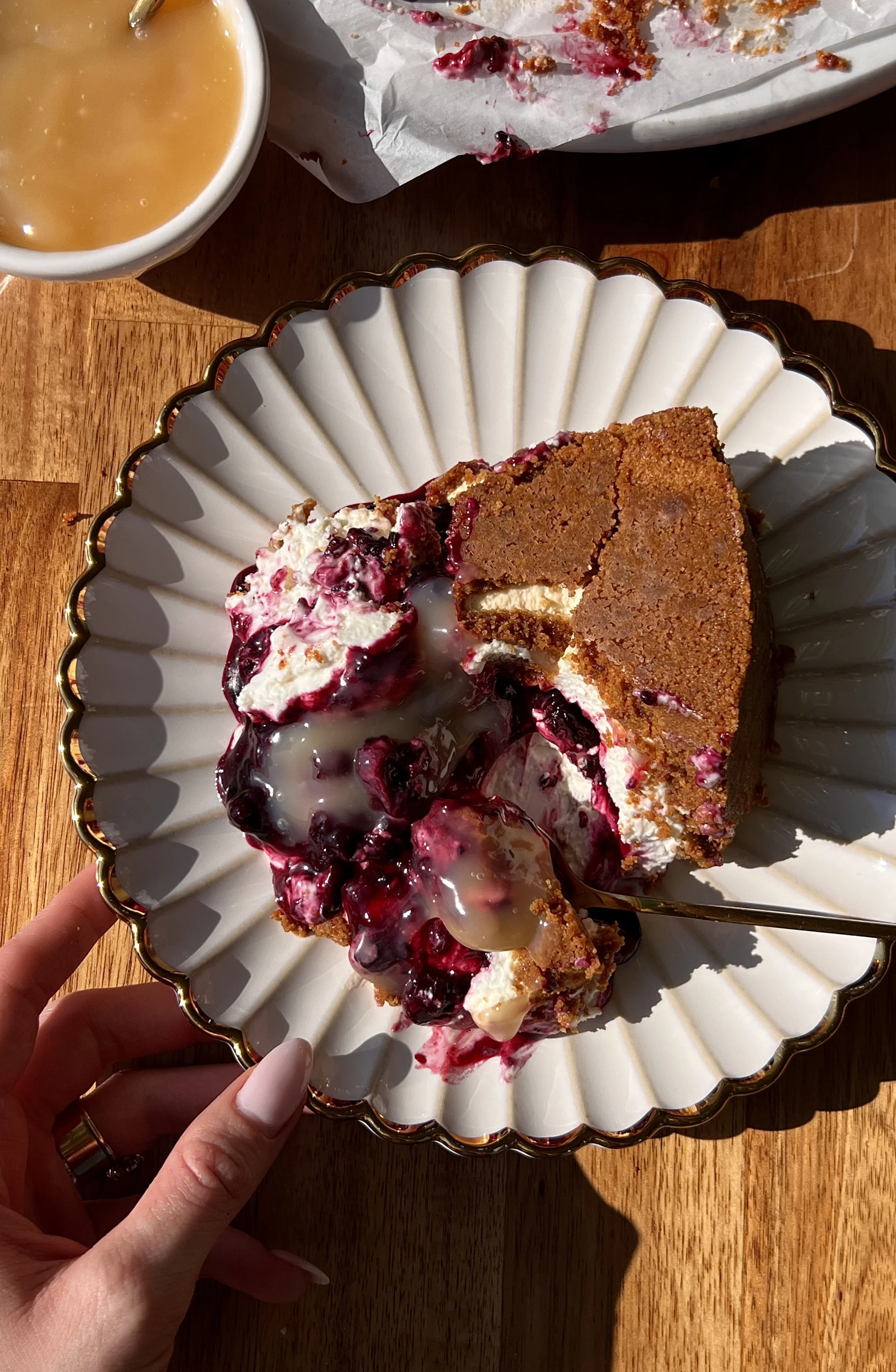 Upside down triple berry no-bake cheesecake with a perfectly crunchy Biscoff cookie crust inverted to serve and finished with a dollop of bright lemon curd on top.