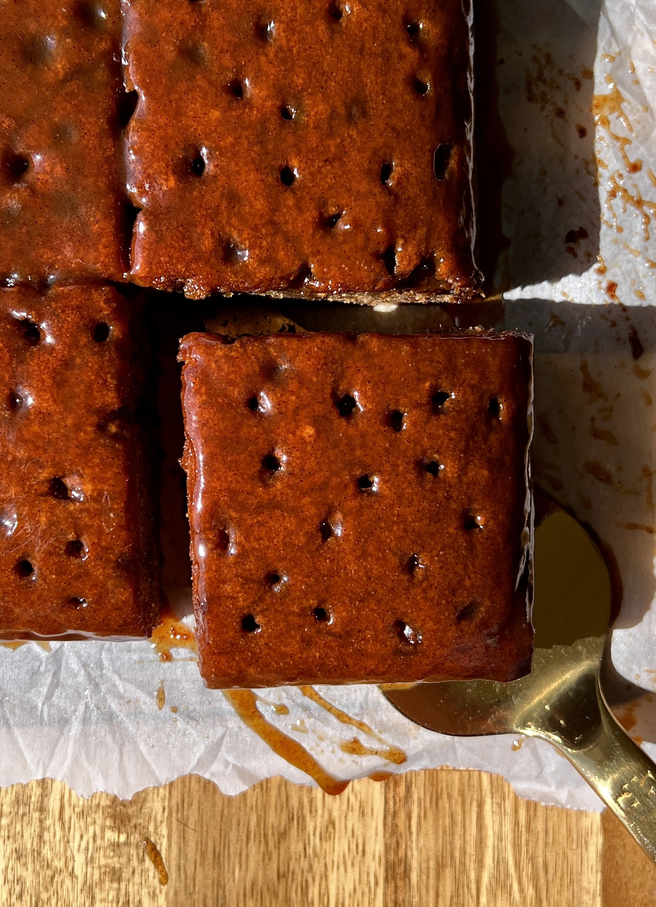 Close-up of a sweet potato sticky toffee pudding showing the insanely soft and tender beautifully spiced cake soaked with a silky sweet potato toffee sauce melting into every crack throughout.