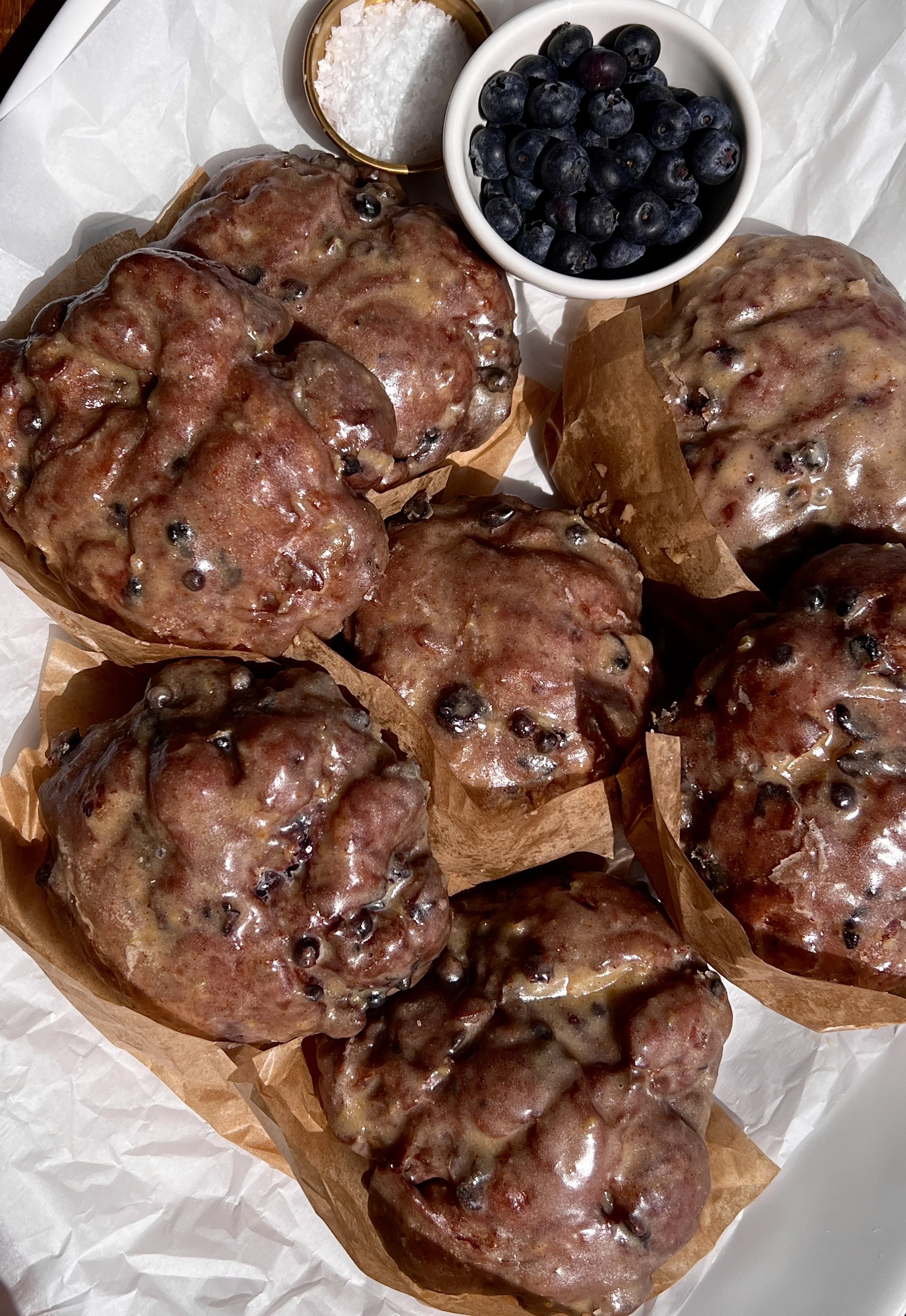 Blueberry fritters coated in a silky brown butter lemon glaze served warm with a hot cup of coffee.