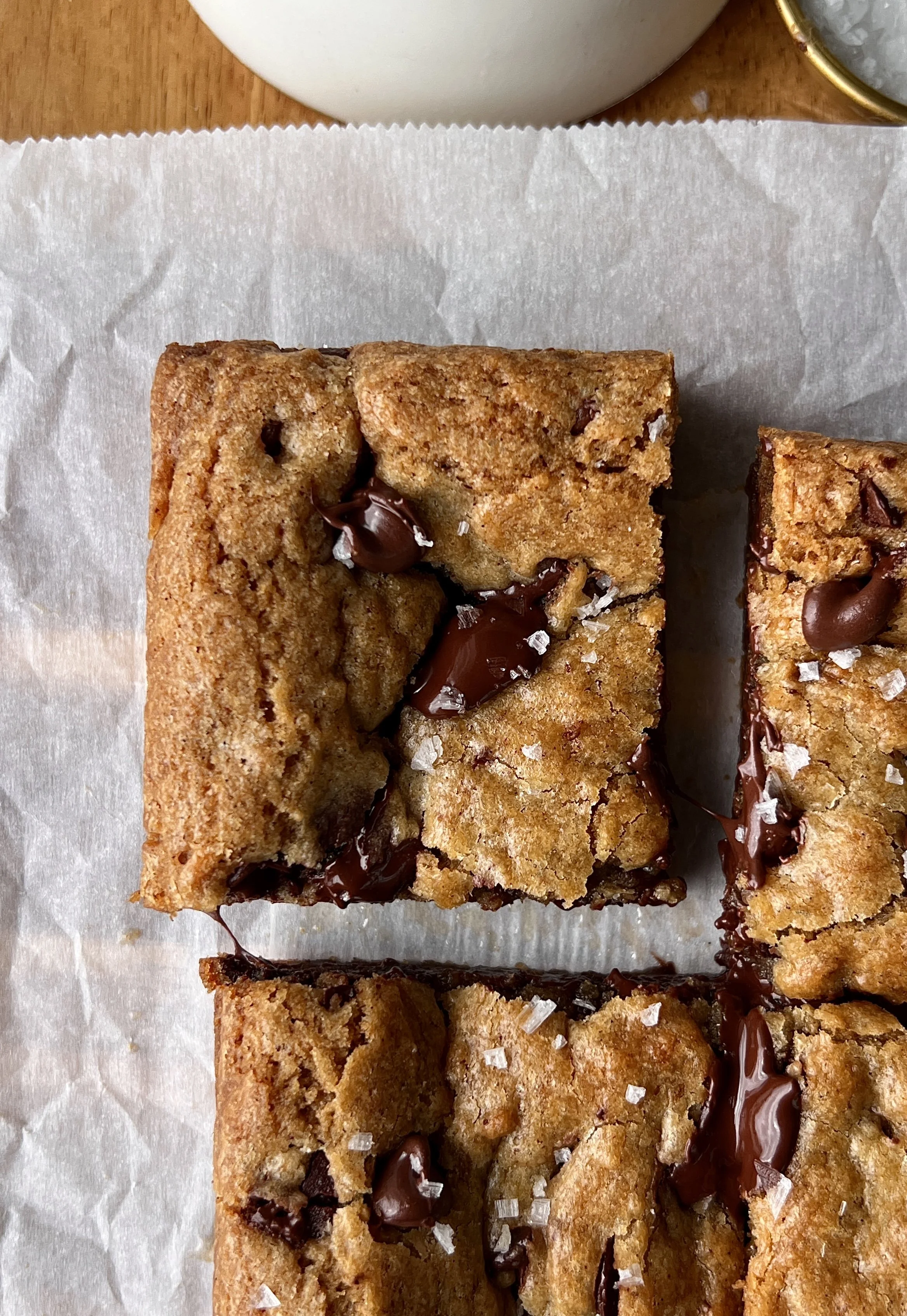 Close-up of a brown butter banana bread chocolate chip cookie bar showing the soft and gooey center with melty chocolate chips throughout and perfectly crisp and golden edges.