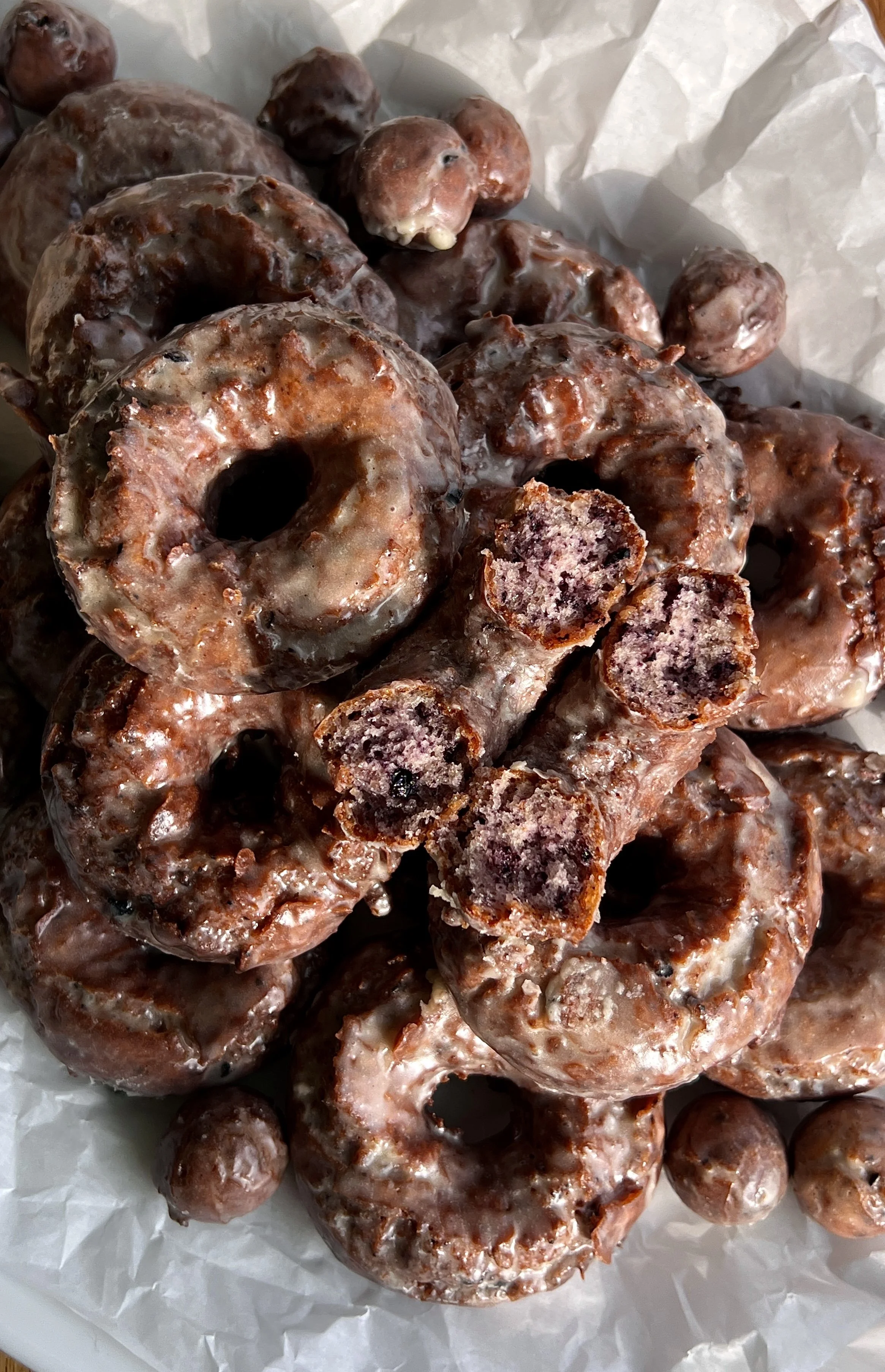 Old-fashioned blueberry cake donuts with vanilla bean glaze and signature cracked tops.