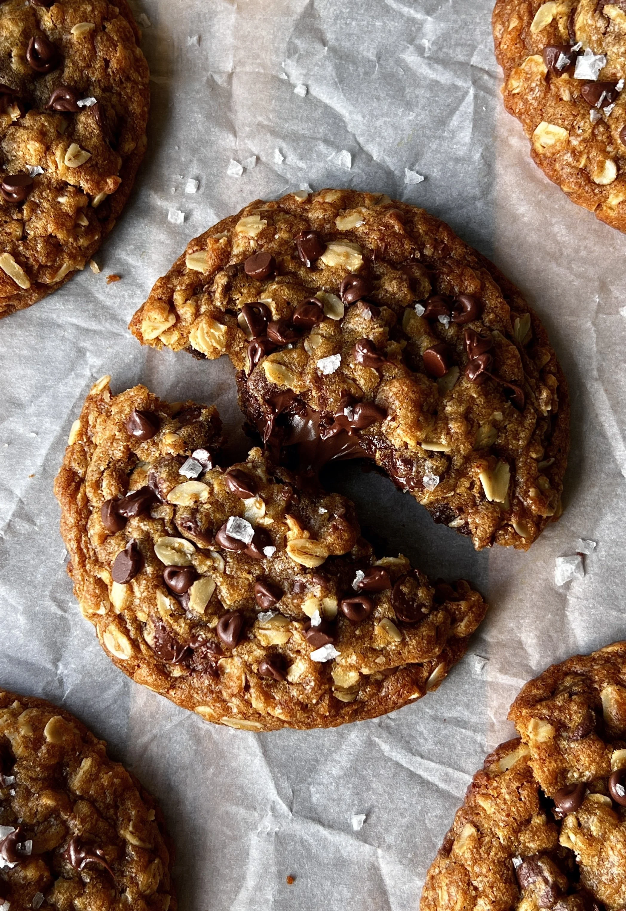 Nutella stuffed pumpkin oatmeal cookie with brown butter broken in half showing the gooey Nutella center melty chocolate chips and soft spiced pumpkin oatmeal cookie interior with perfectly crisp golden edges.
