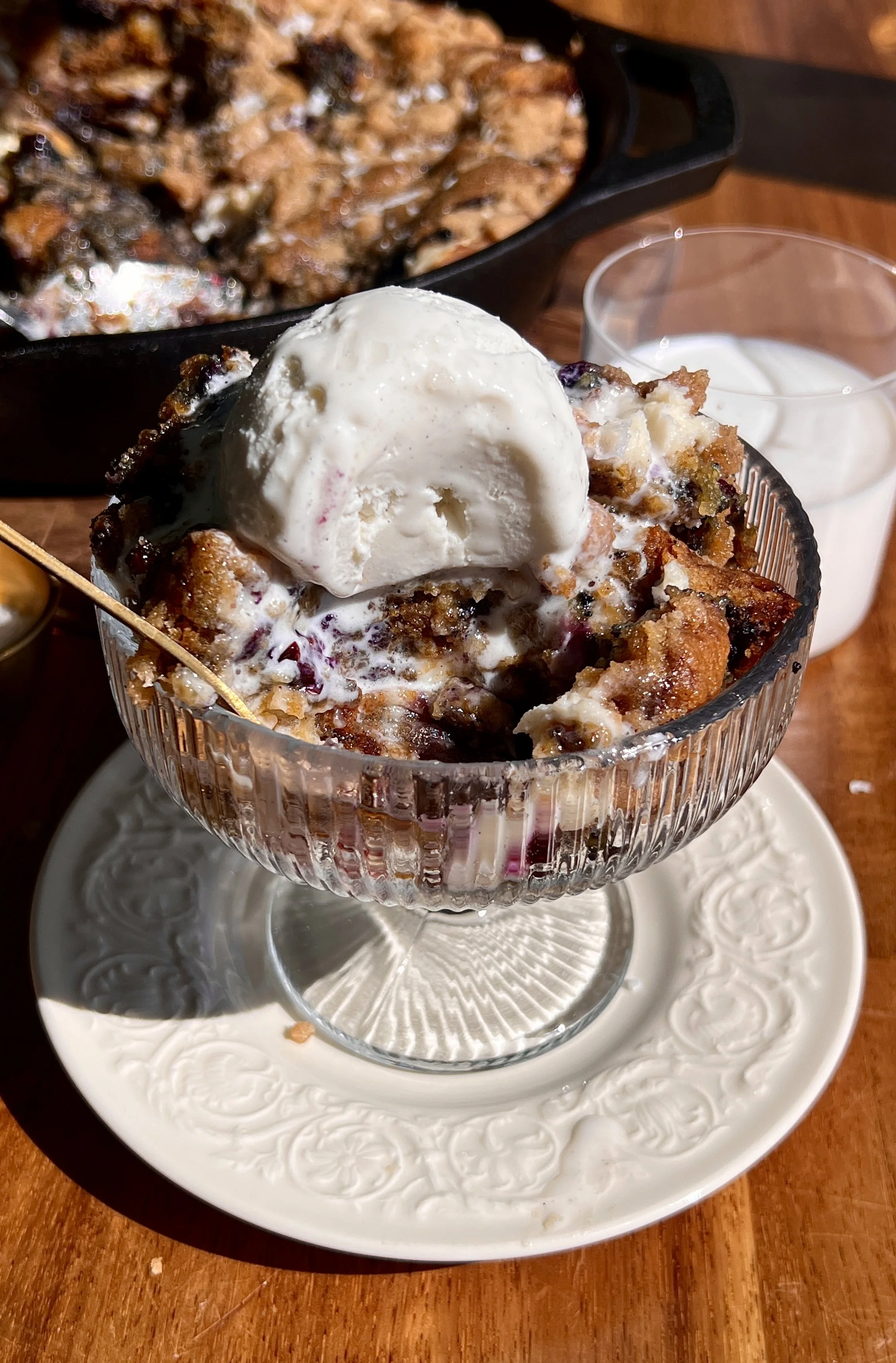 Warm brown butter blueberry crumble cookie skillet served with vanilla ice cream and flaky sea salt.