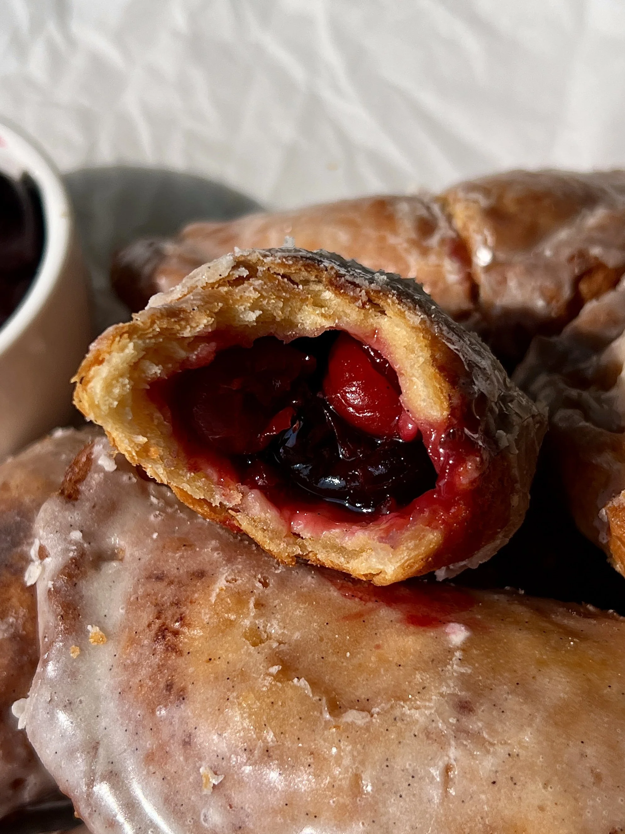 Fried cherry hand pie with a bite taken out showing the golden flaky buttery crust and sweet and tart homemade cherry pie filling bursting inside.