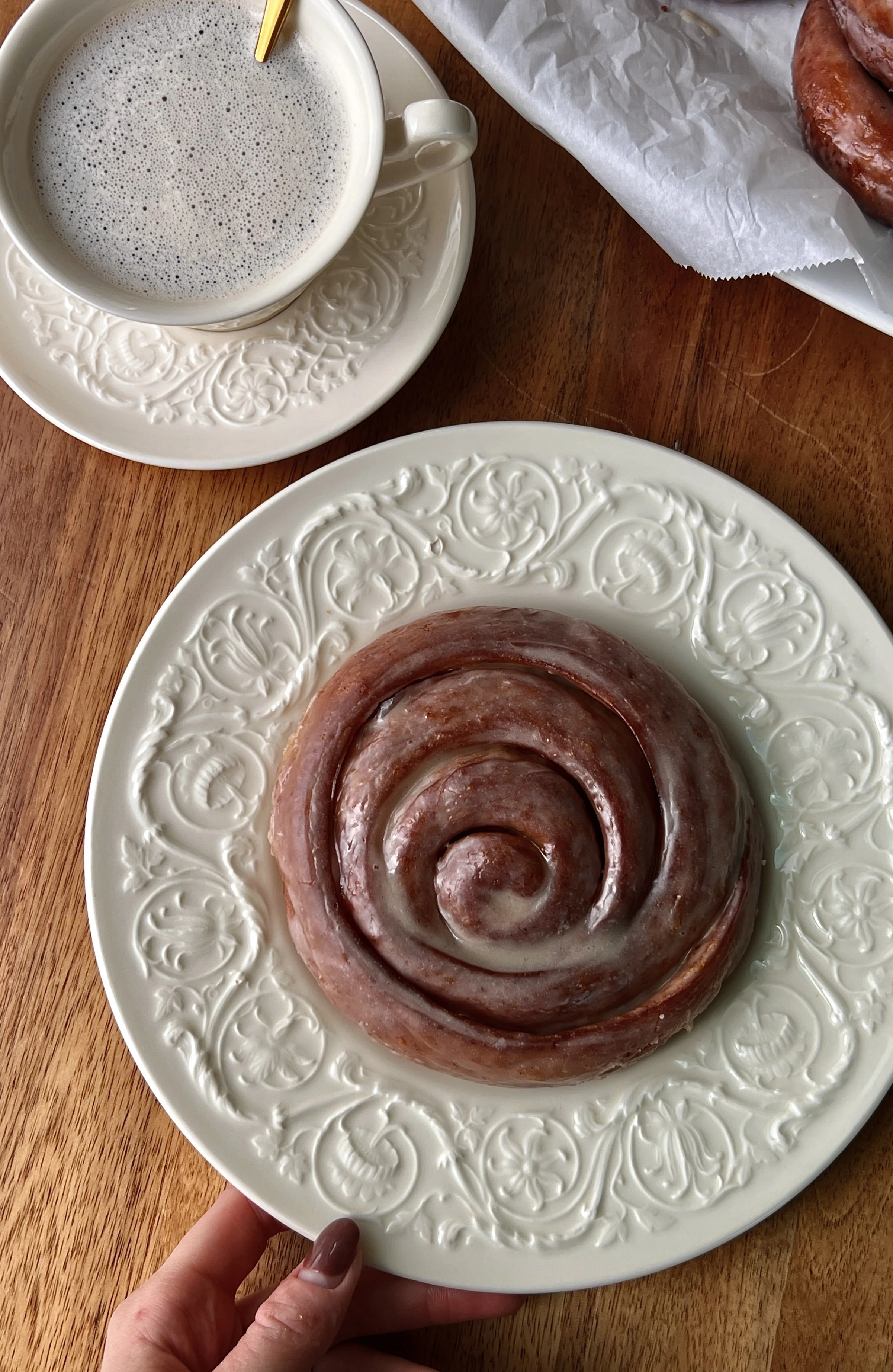 Fried pumpkin spice honey buns with a beautifully golden exterior, gooey swirls of honey butter and pumpkin spice brown sugar filling, and a honey glaze served warm with a hot cup of coffee.