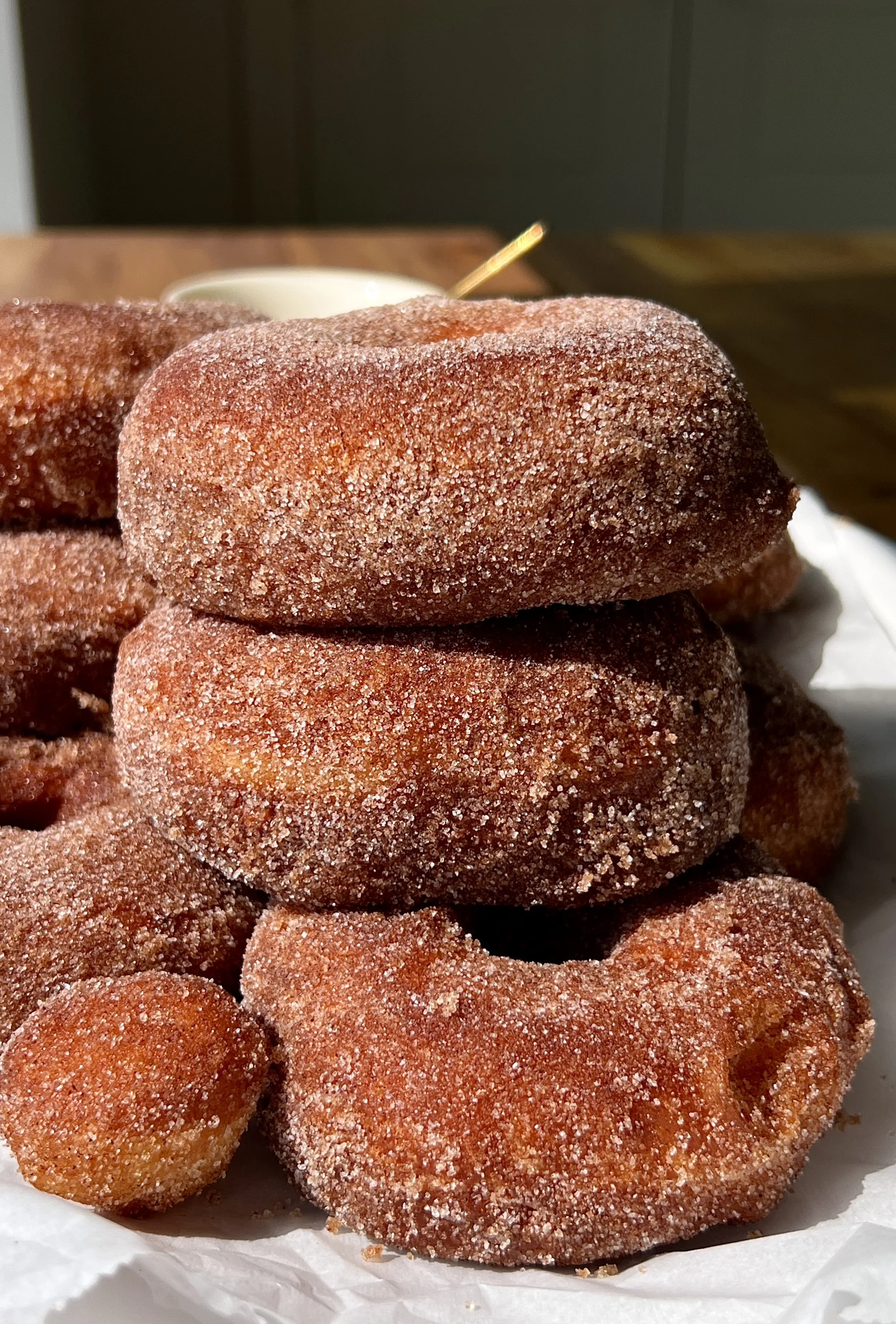 Close-up of a pillowy soft cinnamon sugar milk bread donut showing the beautifully golden exterior with just the right amount of chew and the incredibly soft and fluffy interior throughout.