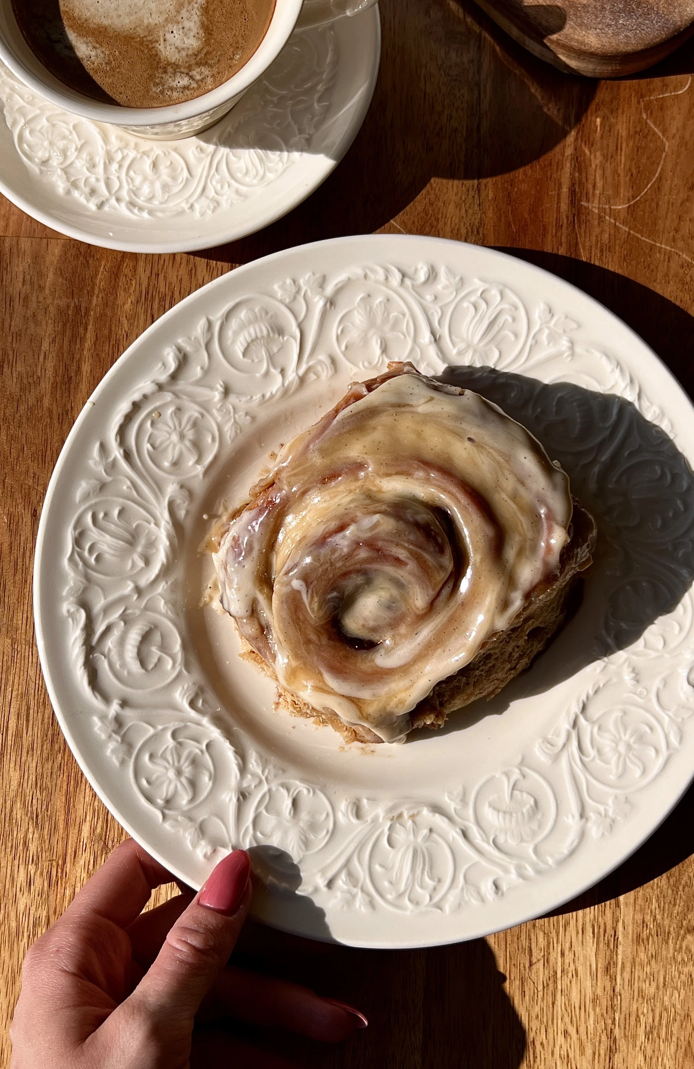 Soft and fluffy sticky toffee pudding cinnamon rolls with a pull-apart date dough and warm gooey cinnamon date filling finished with a rich maple toffee sauce and brown sugar cream cheese frosting served warm with a hot cup of coffee.