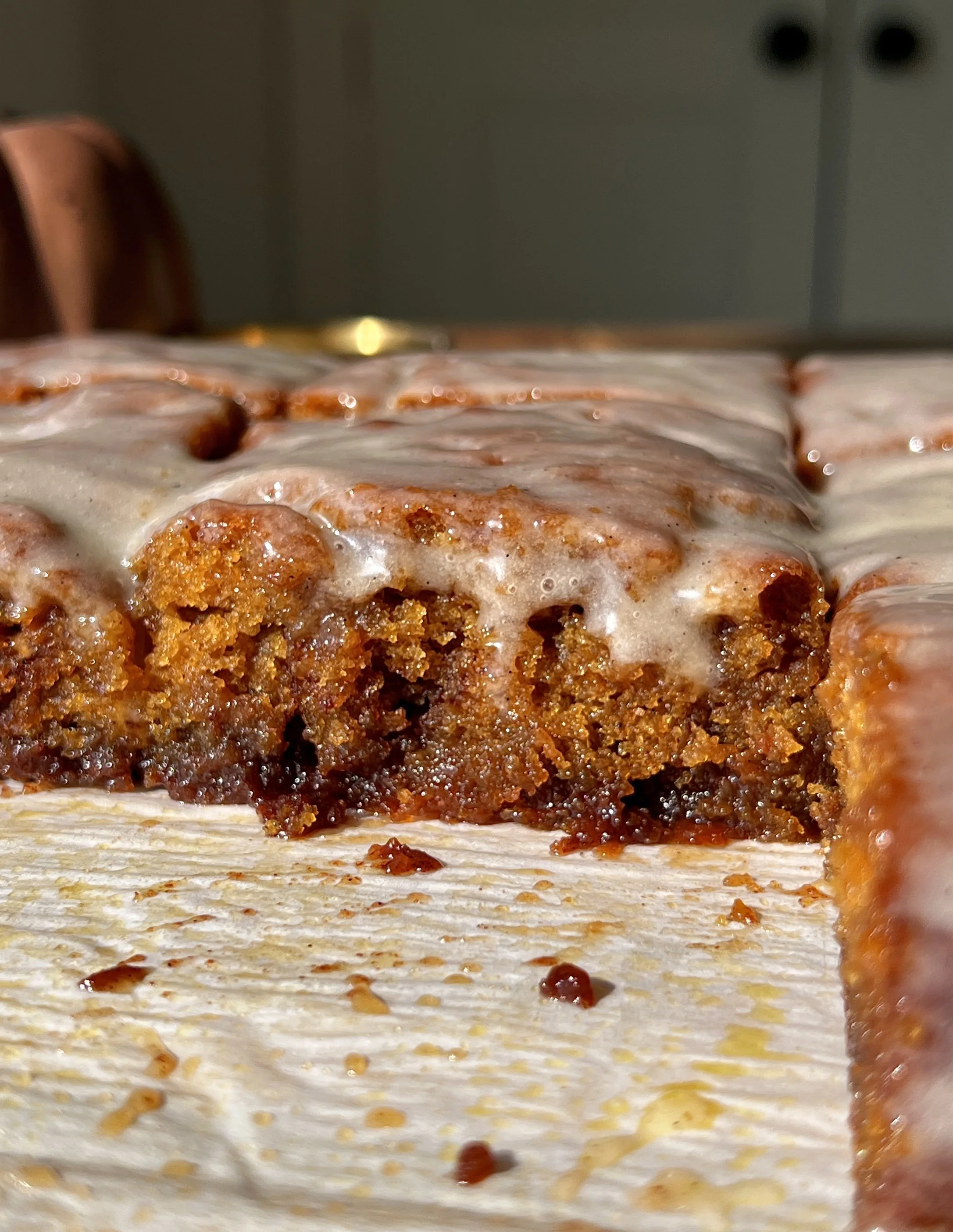 Close-up of a pumpkin honey bun cake showing the soft and tender delicate spiced pumpkin crumb with a cinnamon brown sugar swirl throughout and honey cream cheese glaze melting over the top.