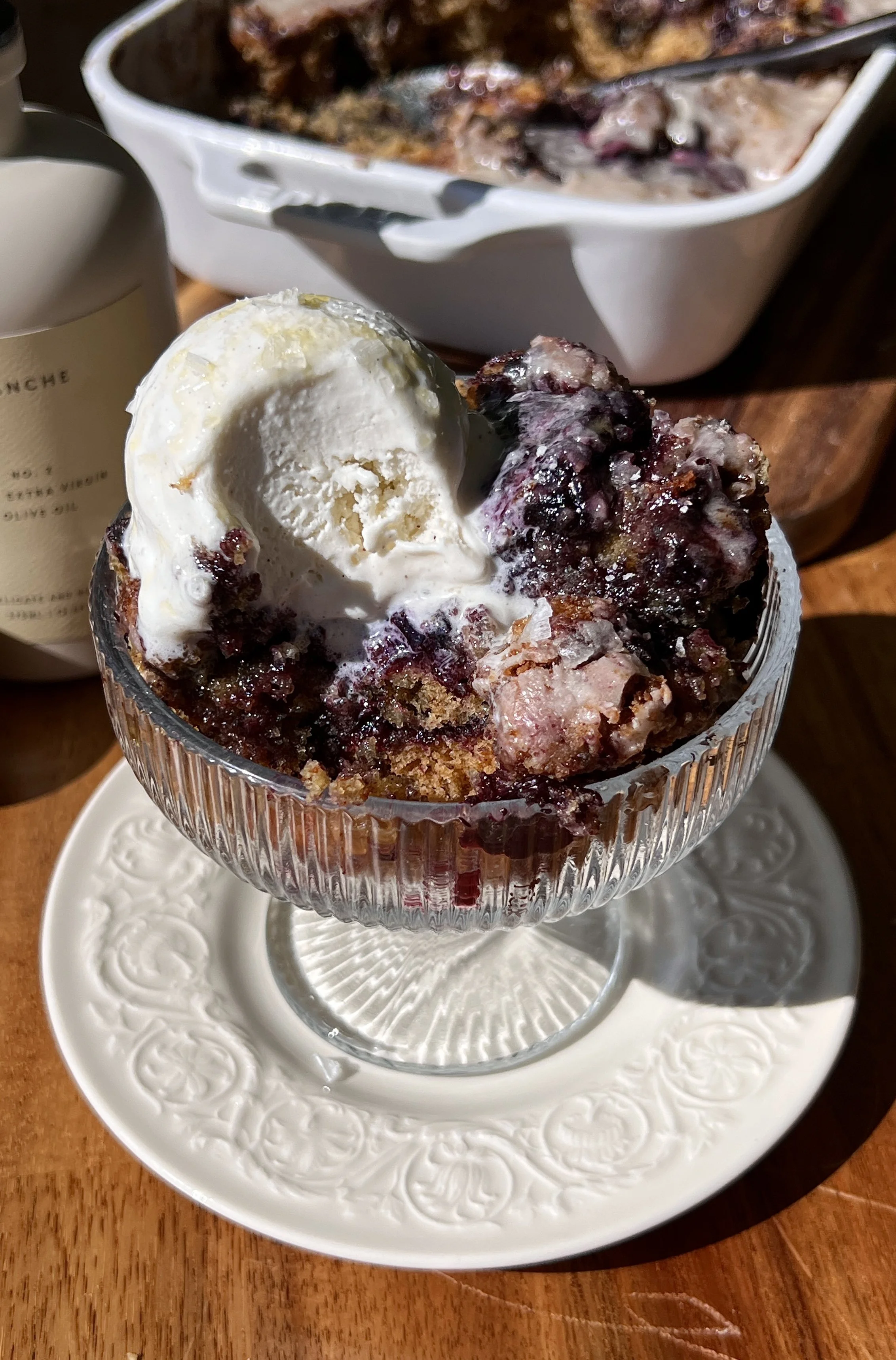 Soft and fluffy brown butter blueberry fritter cake swirled with cinnamon filling and homemade blueberry compote finished with a maple vanilla bean glaze served warm with a scoop of vanilla ice cream and flaky sea salt.