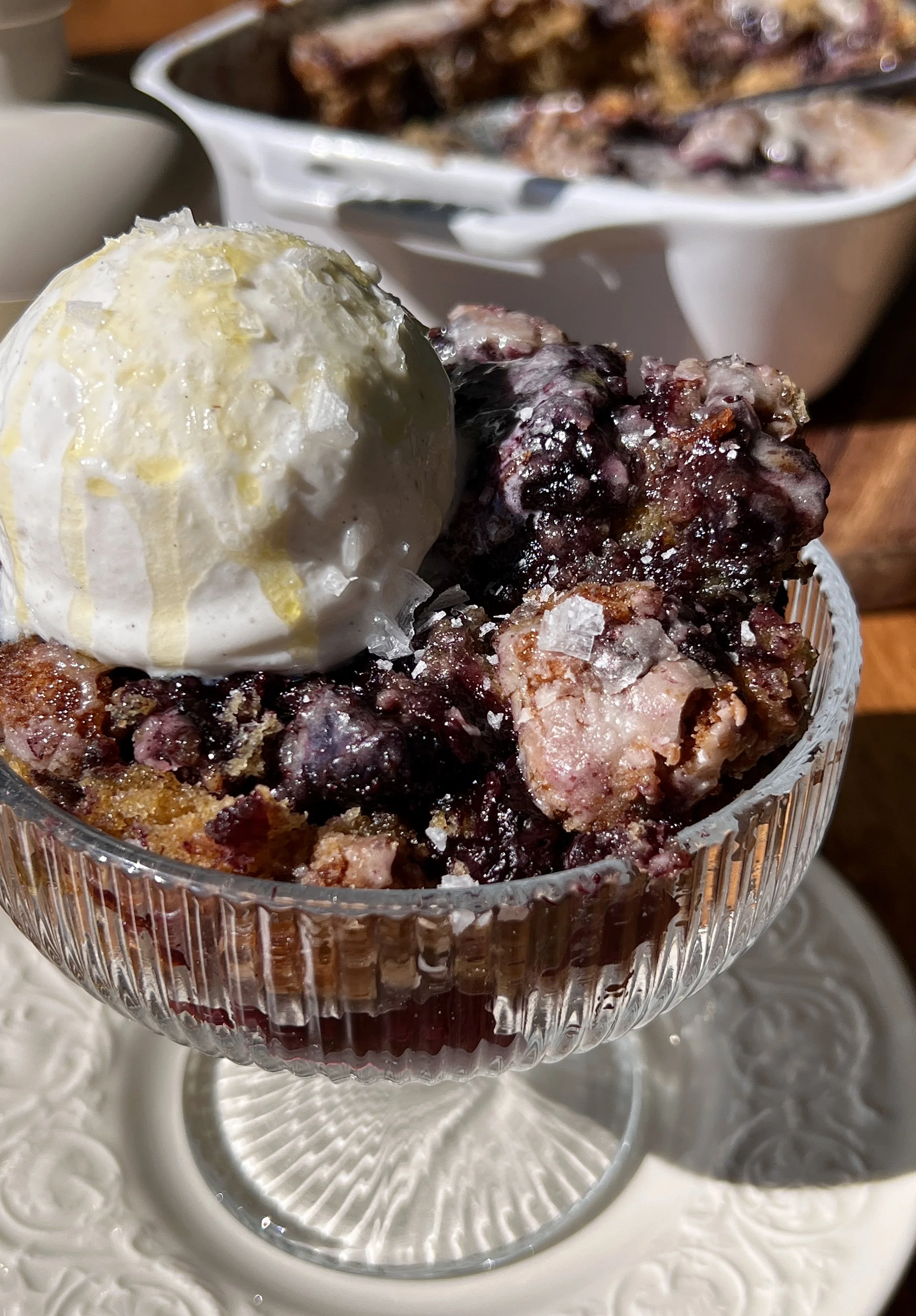 Close-up of a soft and fluffy brown butter blueberry fritter cake with a warm cinnamon filling and homemade blueberry compote swirled throughout.