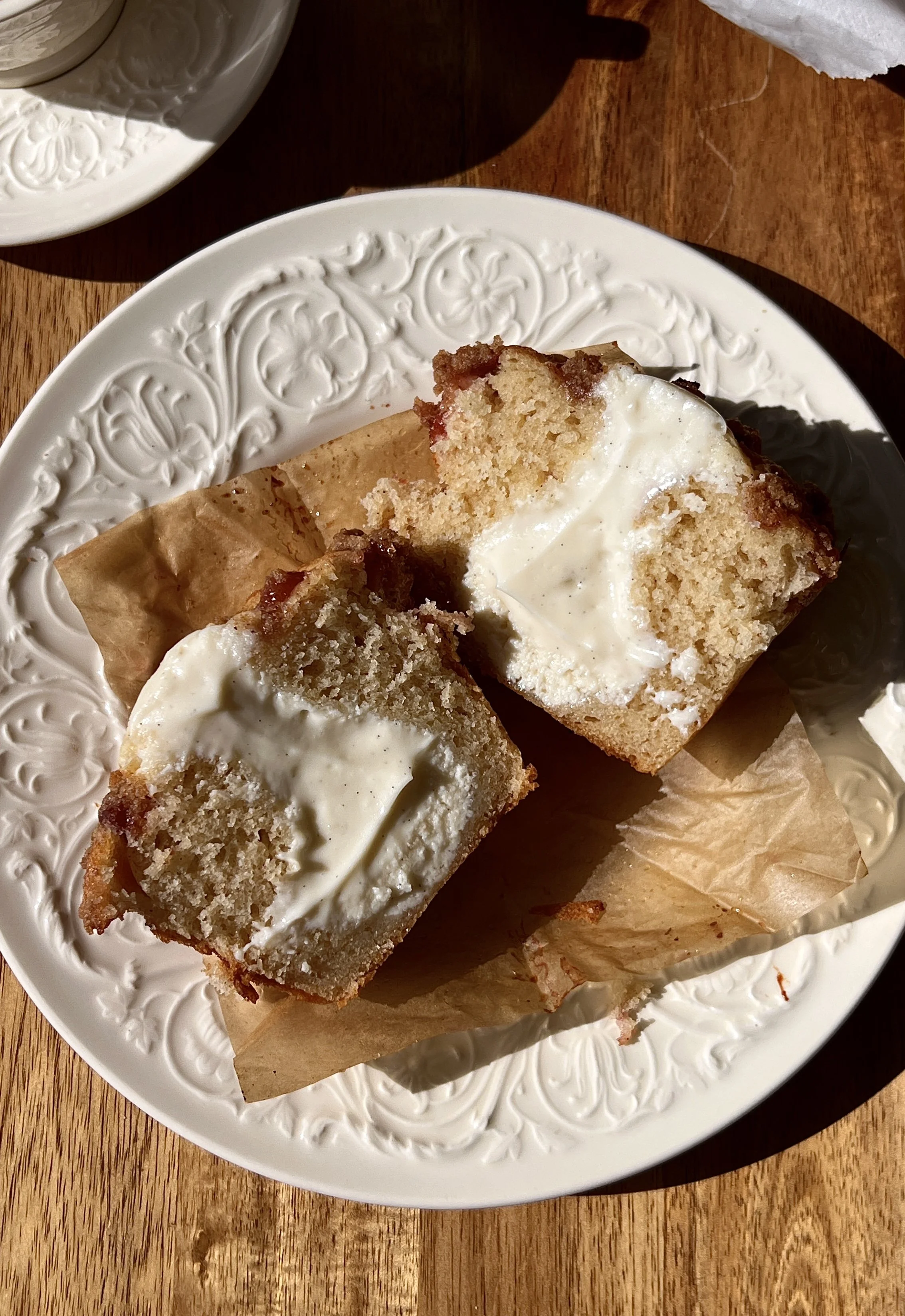 Close-up of a soft and fluffy bakery-style peach cobbler cream cheese muffin with a tender crumb, bright peach flavor, and buttery crumb topping throughout.