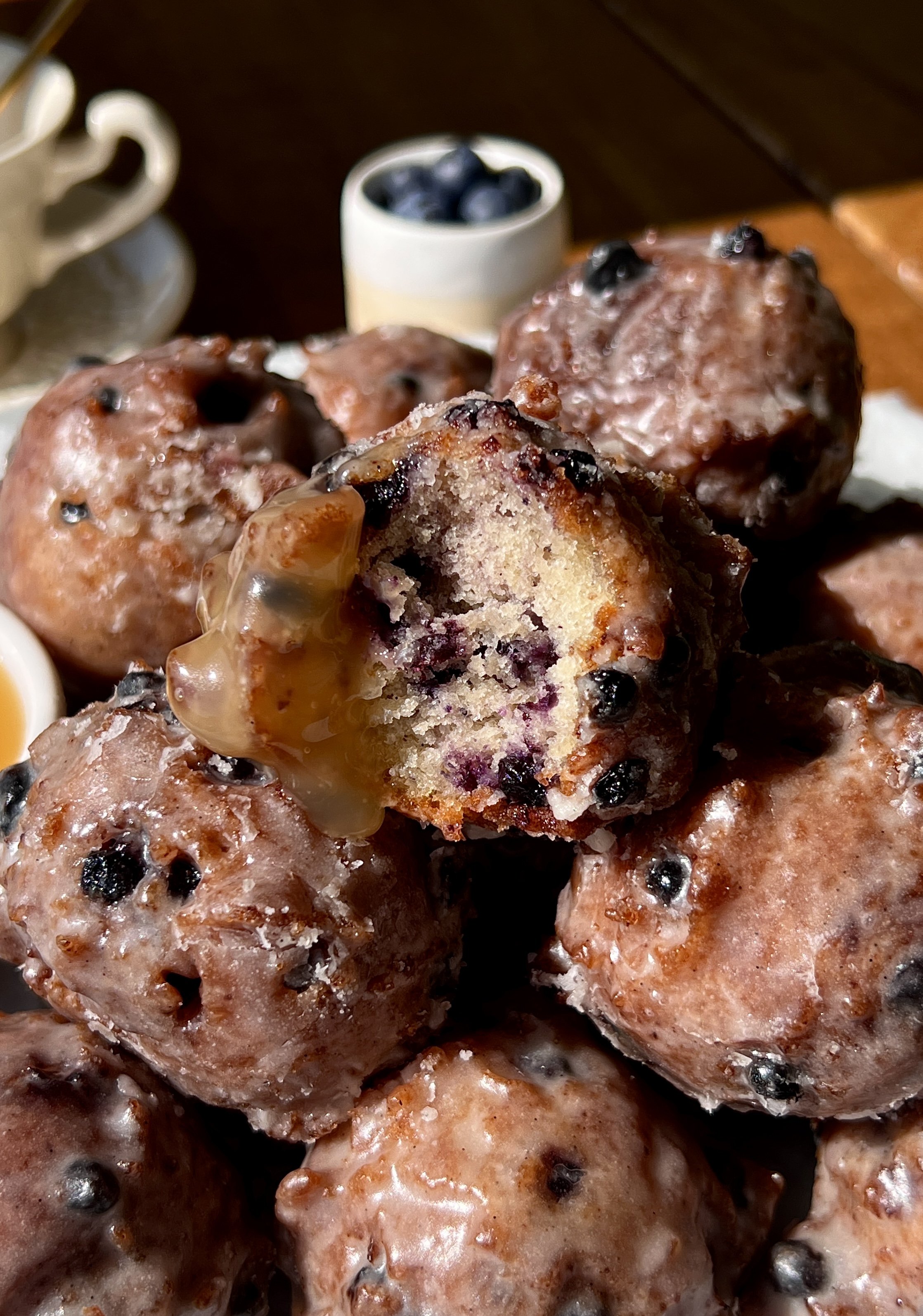 Soft and tender sourdough blueberry fritter bites with a beautifully golden exterior and bright juicy blueberries throughout coated in a silky vanilla bean glaze that melts into every crack and crevice served warm with a hot cup of coffee.