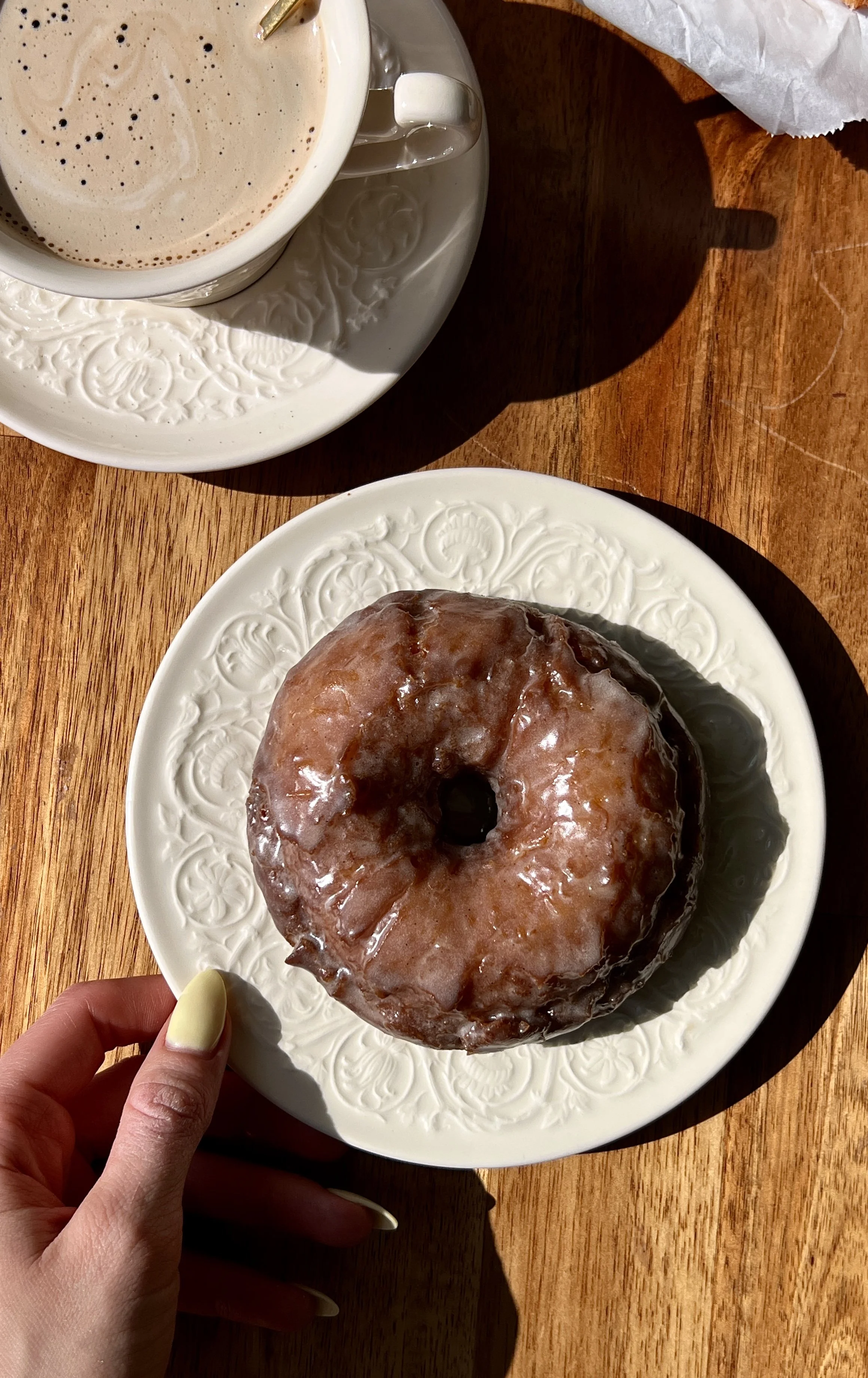 Soft and fluffy old-fashioned sour cream donuts with a perfectly golden and slightly crisp exterior coated in a silky vanilla bean glaze that melts into every crack and crevice served warm with a hot cup of coffee.